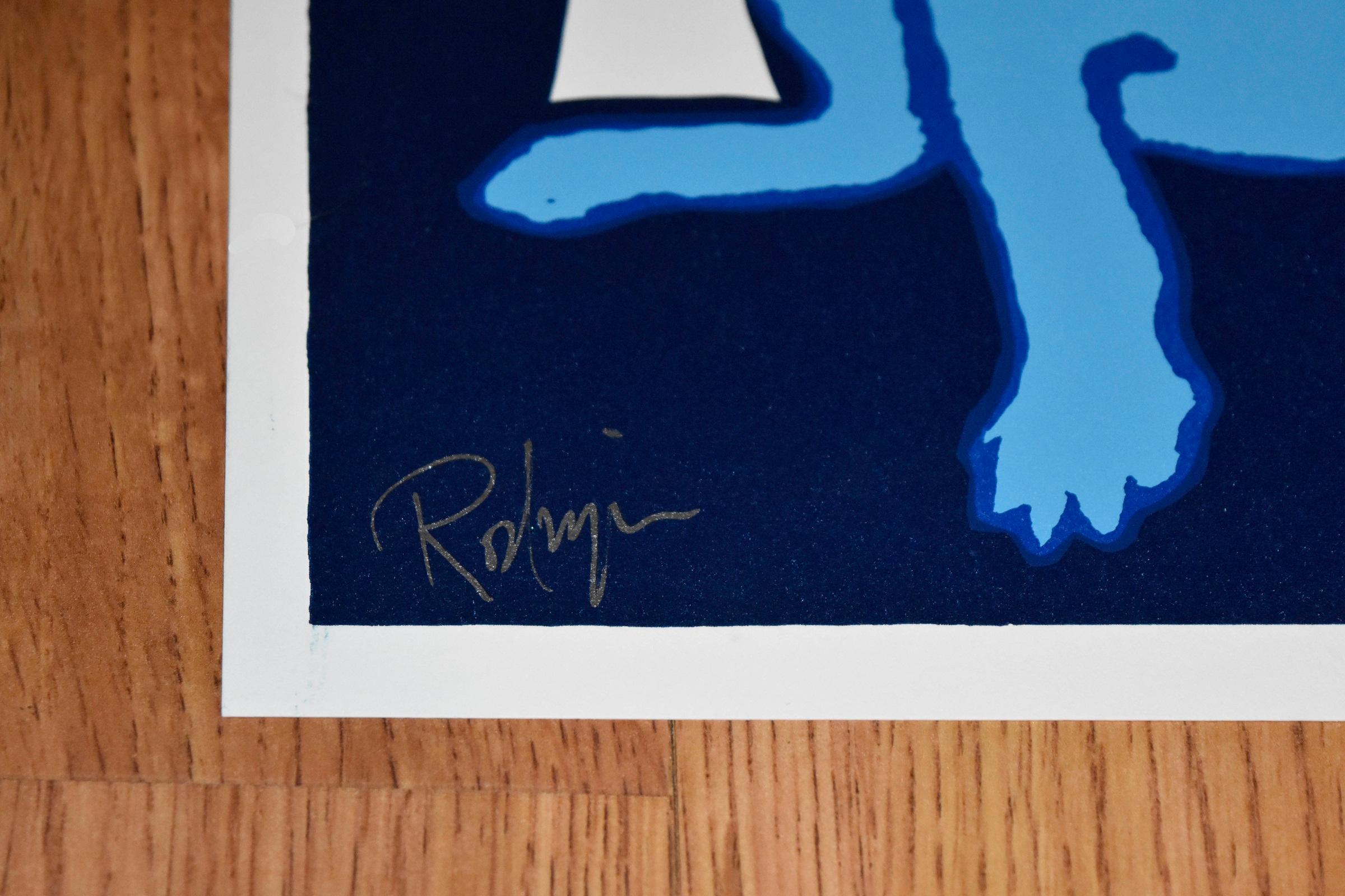 Cette œuvre Chien bleu est composée d'un chien bleu centré assis sur un fond noir avec une seule bougie blanche allumée à ses côtés. Le chien a des yeux jaunes pleins d'âme.  Cette sérigraphie originale pop art animalière sur papier est signée à la