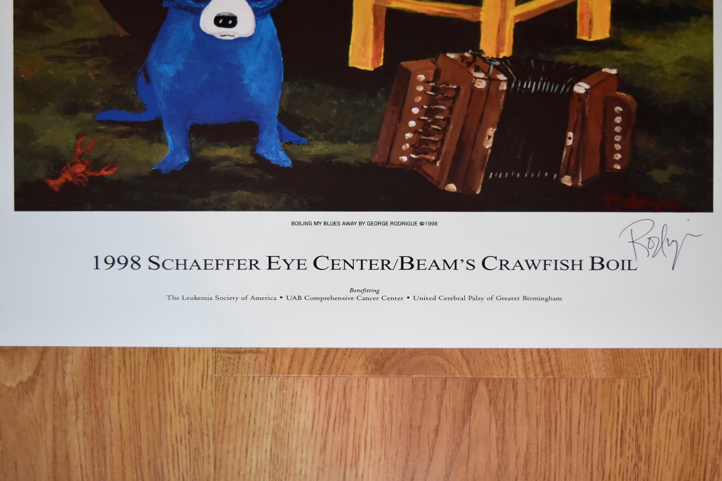 This Blue Dog work consists of a blue dog on a background of green fields, blue sky, and a bronze statue on a white pedestal.  There is one blue dog sitting on the grass and one red dog sitting on a yellow chair with an accordion on the grass and a