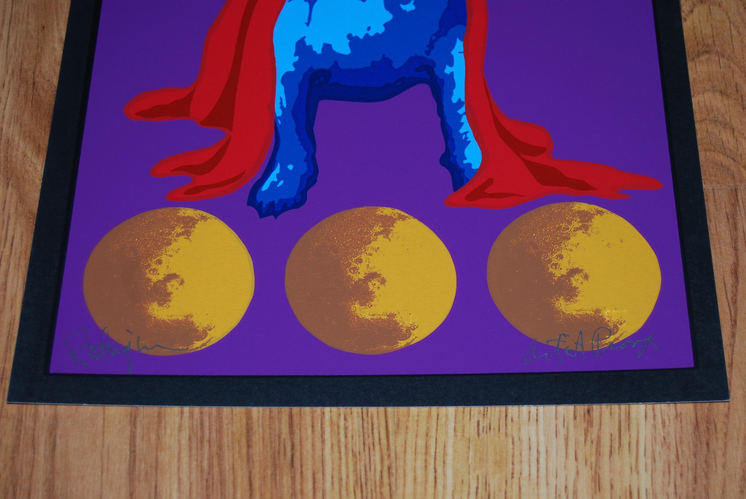 This Blue Dog work consists of a purplish/blue background, a blue dog with a red cape covering head, ears and body, sitting atop 3 brownish/yellow moons.  The dog has soulful yellow eyes.  There is also a painted black border surrounding the entire