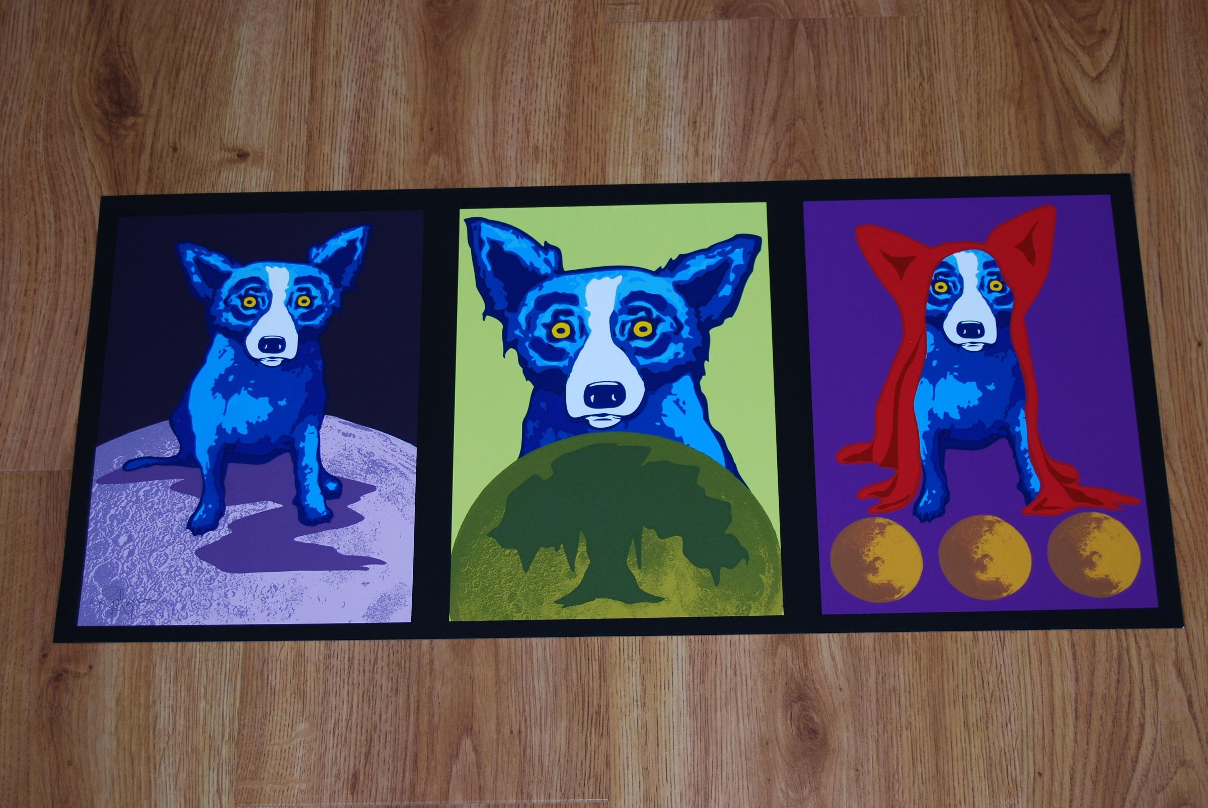 This Blue Dog work consists of 3 dogs each framed in black with multiple backgrounds.  One dog is sitting on a purple moon with a black background, 1 dog is sitting behind an olive colored orb with a darker green tree and a light green background,