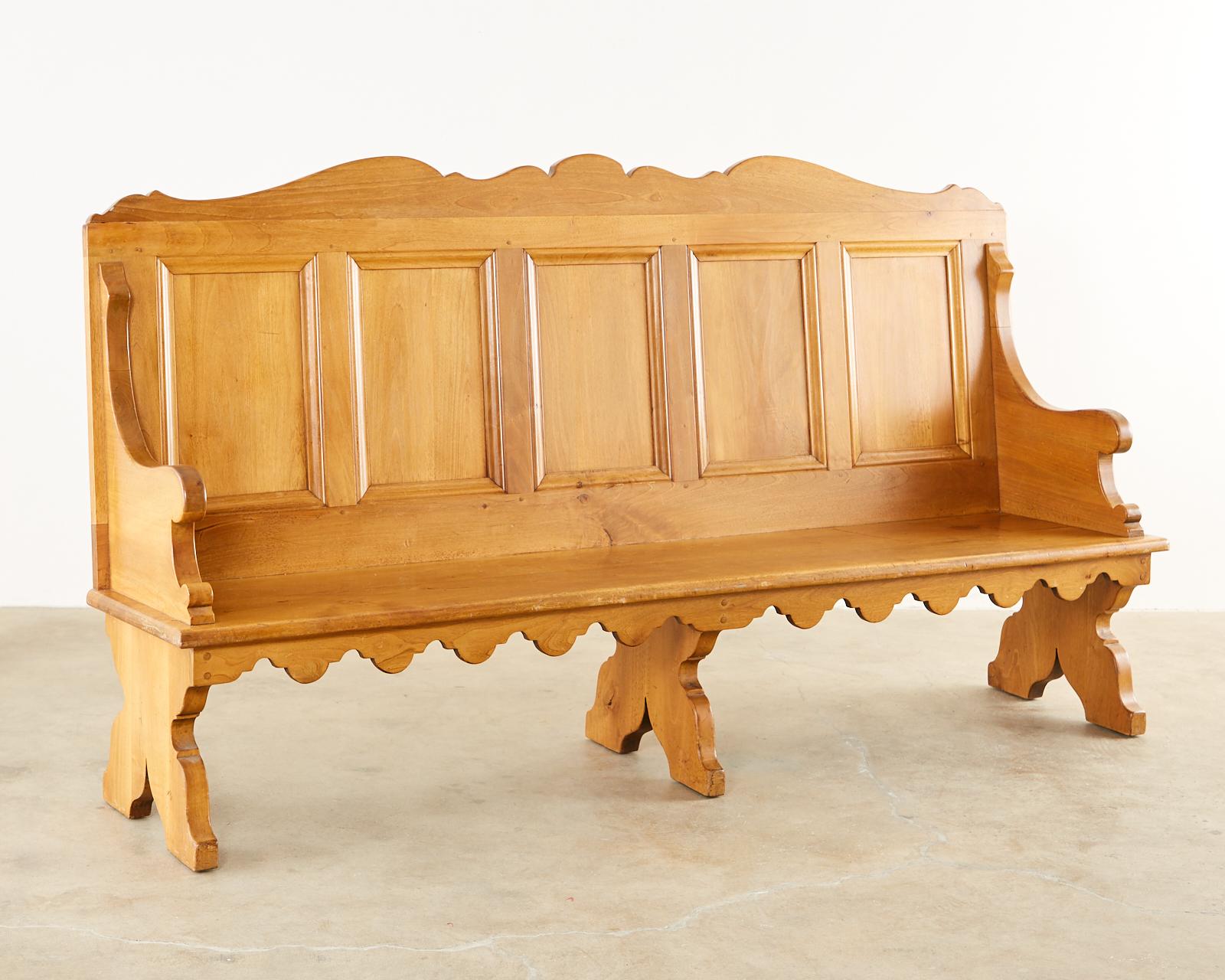 Pair of distinctive gothic revival style church pew benches made by George S. Hunt designer/furniture maker in Pasadena, CA. Beautifully crafted with a paneled back and gracefully curved arms. Decorated with a shaped apron on the seat and supported