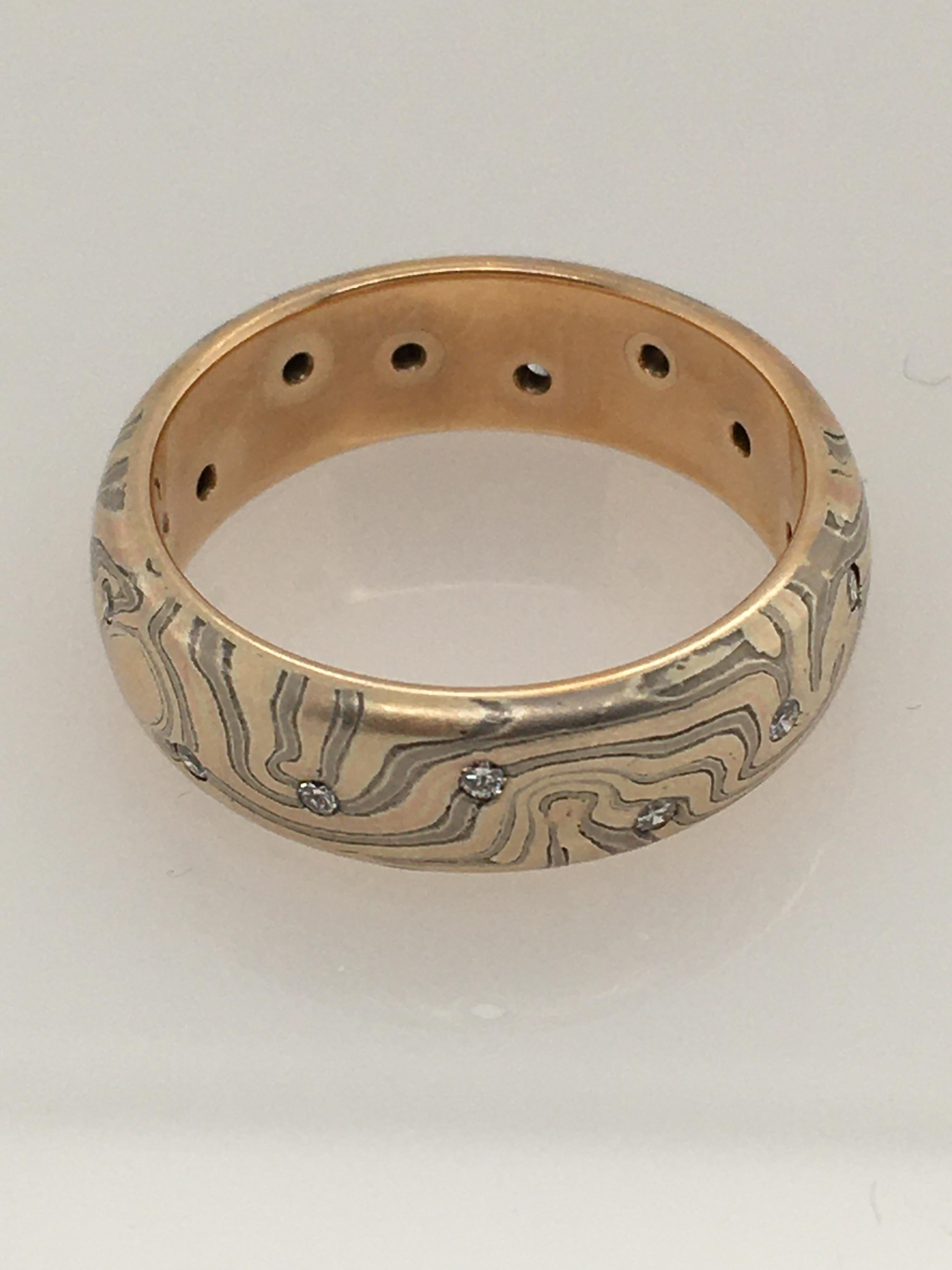 A dramatic George Sawyer half-round band ring of  14KY red & gray gold with etched sterling silver in a traditional Mokume style.  The band features 15 round flush set diamonds, .15 TCW.   Style Number is R6C15F.  Interior stamp 
