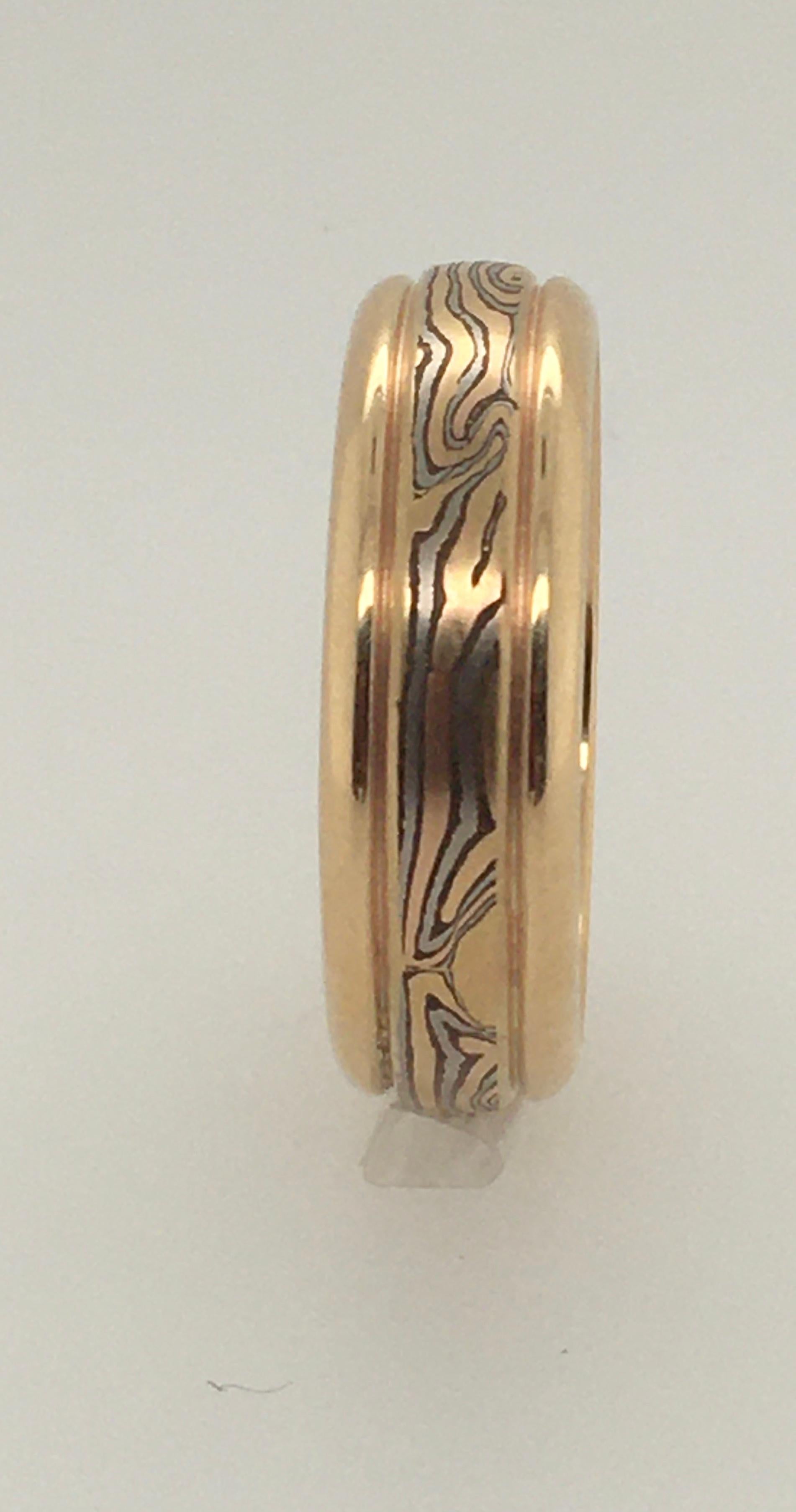 This dramatic George Sawyer round edge 6 mm Mokume wedding band features 14K red & gray gold with etched sterling silver.  Interior is stamped 