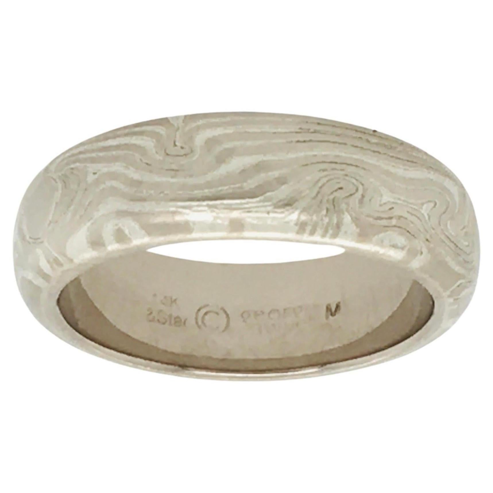 A striking half round wedding band by George Sawyer in the traditional Mokume style.   This 6 mm ring features 14K Gray Gold & Etched Sterling.  Interior stamp shows 