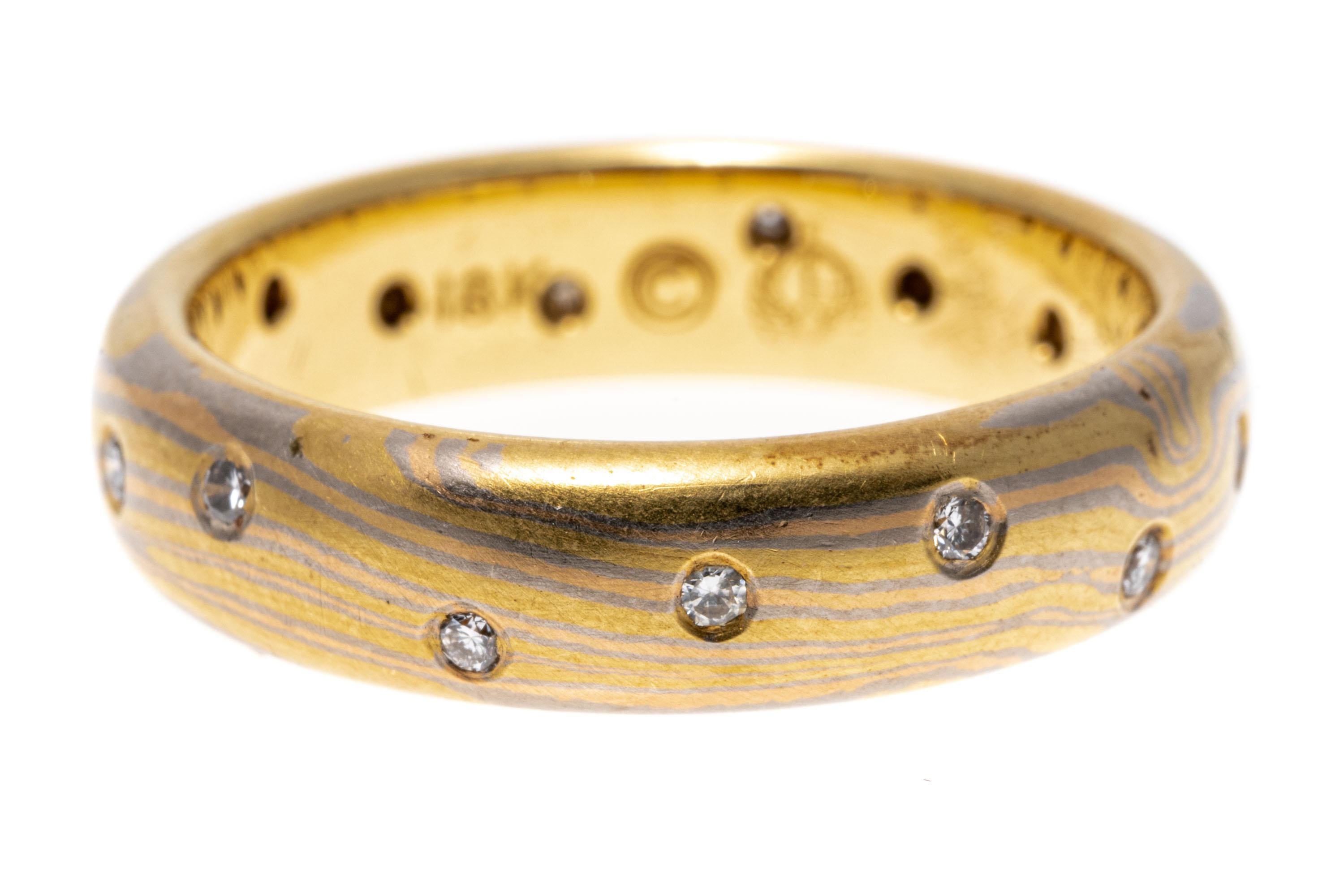 18k gold ring. This magnificent and unique ring, made and signed by George Sawyer in 1995 is a half round style of mokume gani* folded metal, using a combination of yellow, rose and grey golds and is set with scattered round faceted diamonds,