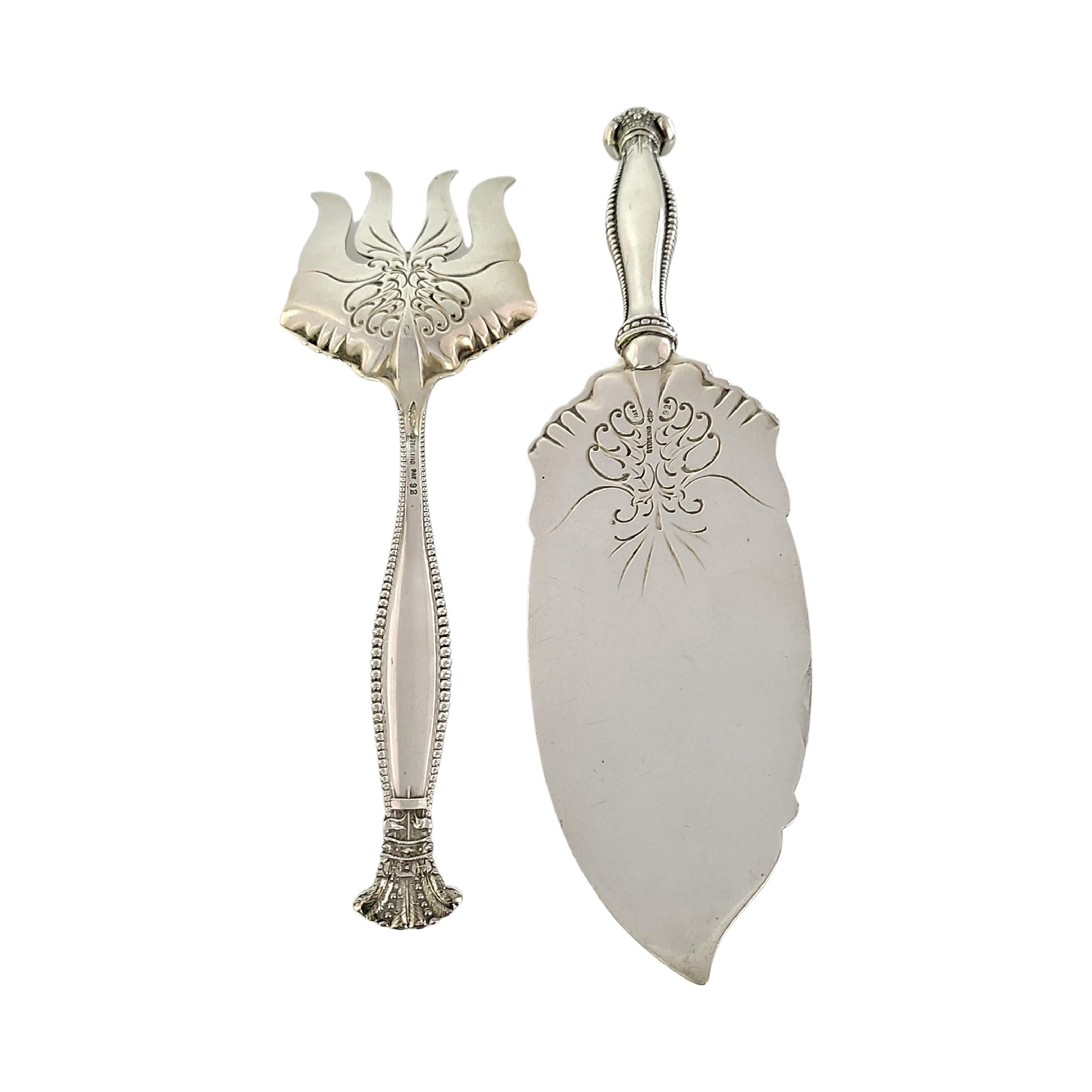 Sterling silver 2pc fish serving set in the Sandringham pattern by Georg Shiebler.

No monogram.

Beautifully ornate fish serving set including a fork and a serving knife/spatula. Beaded hollow handles, flourish design on both pieces.

Knife