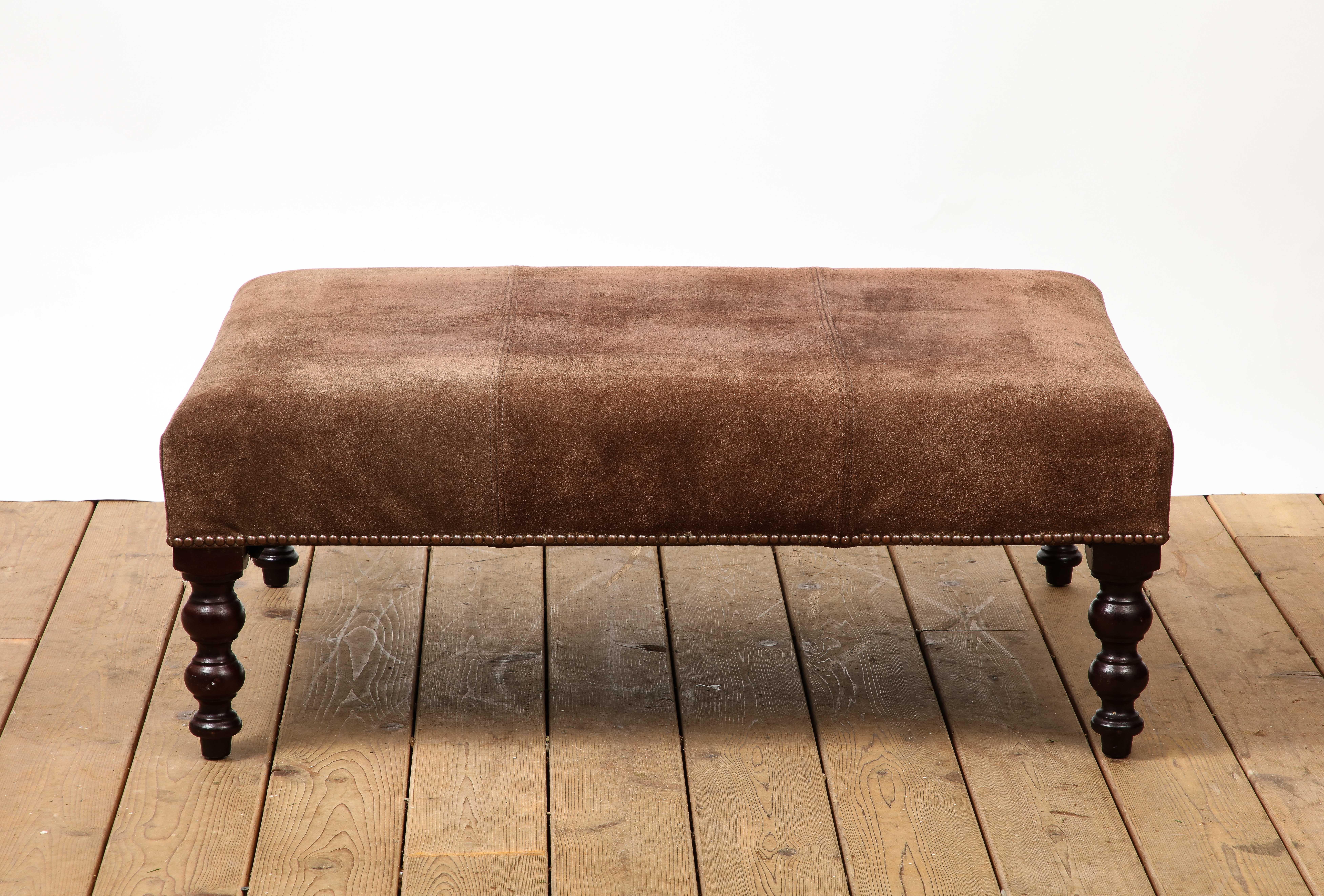 Brown suede rectangular ottoman with nailhead trim and turned wood legs by George Smith. 