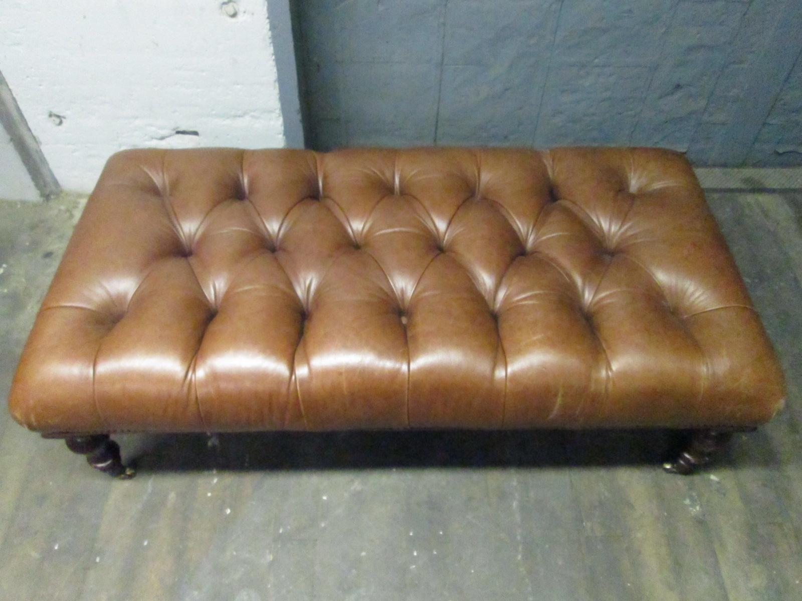 English tufted leather bench with brass casters. George Smith.