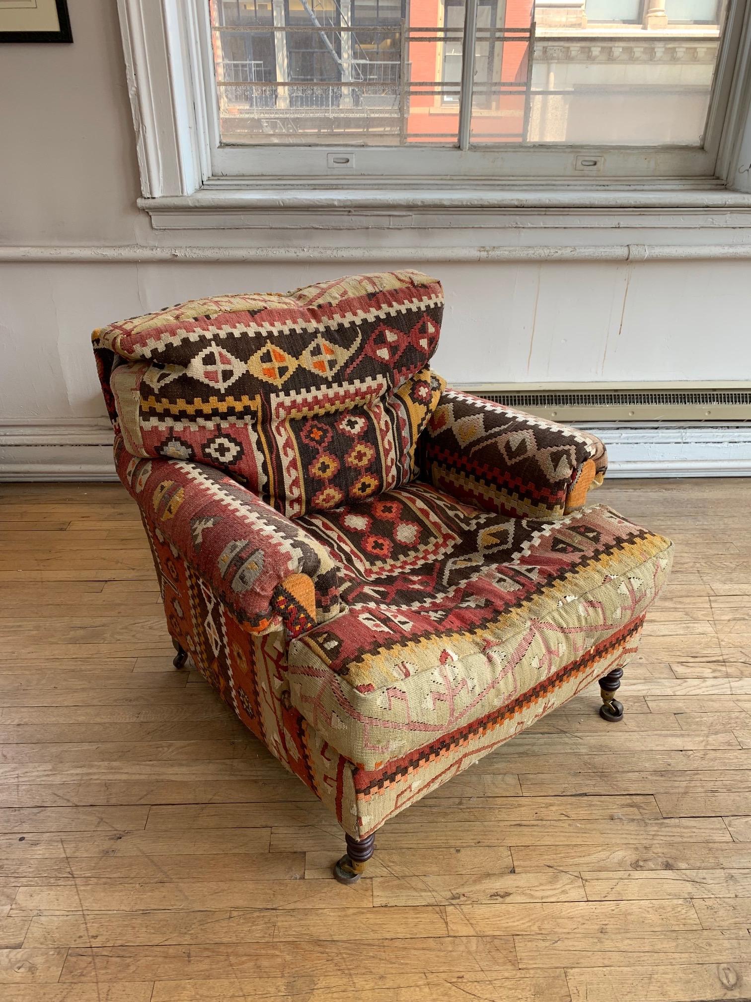 George Smith Kilim armchair
Vibrant Kilim upholstery, roll arm, on small turned front legs on casters, and back squared legs on casters. Down and feather seat and back cushions. 
c. 2000
With label George Smith Ltd.
Good overall condition, light