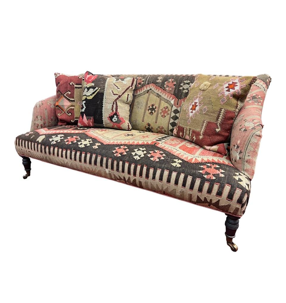 This George Smith style two-seat Kilim upholstered Sofa is crafted with meticulous attention to detail. This exquisite piece transcends trends, making it the perfect addition to any interior. With the rich tapestry of colors, this sofa effortlessly