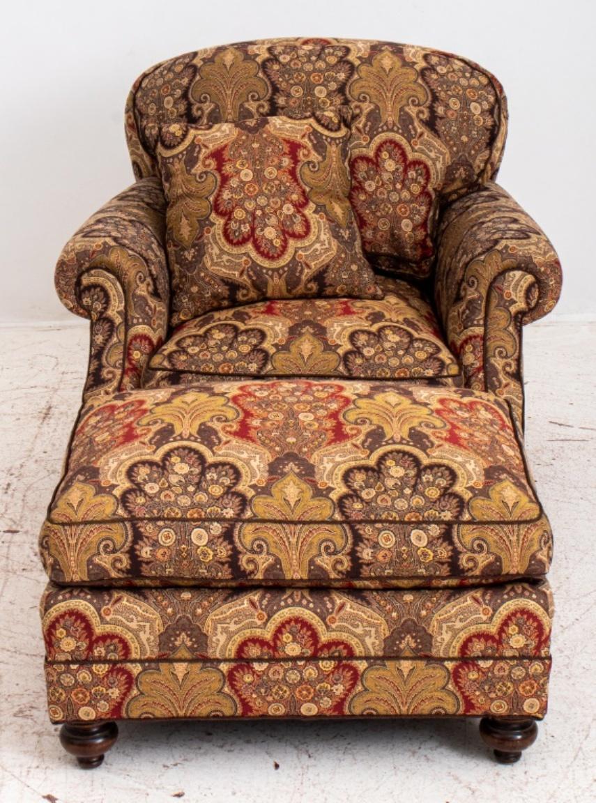 George Smith style upholstered club chair and ottoman, now allover covered in a paisley jacquard, with curving back, rolled arms and drop in cushions, above turned front feet. 35