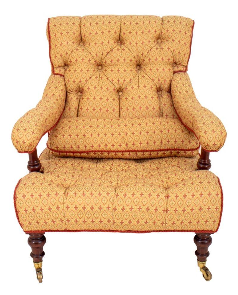 George Smith upholstered low open arm chair with scrolling tufted back and seat with upholstered tufted arms on turned supports, the turned front legs terminating in casters, the back with curving square legs, now upholstered in an ochre and brick