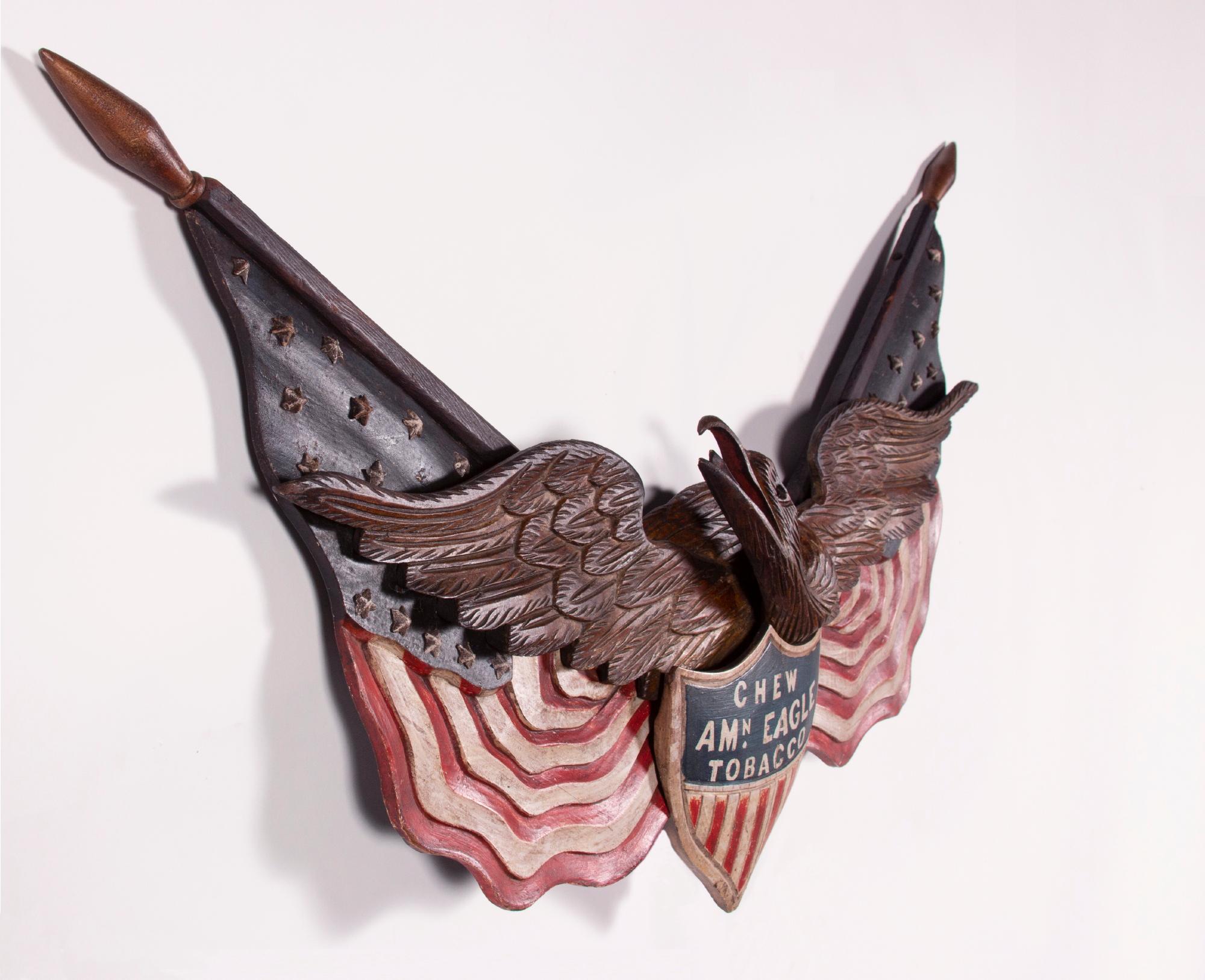 Carved eagle by George Stapf, Harrisburg, Pennsylvania, an exceptional example with two outstretched American flags and a federal shield, one of just two known examples with commercial advertising, made circa 1890-WWI

Patriotic eagle by