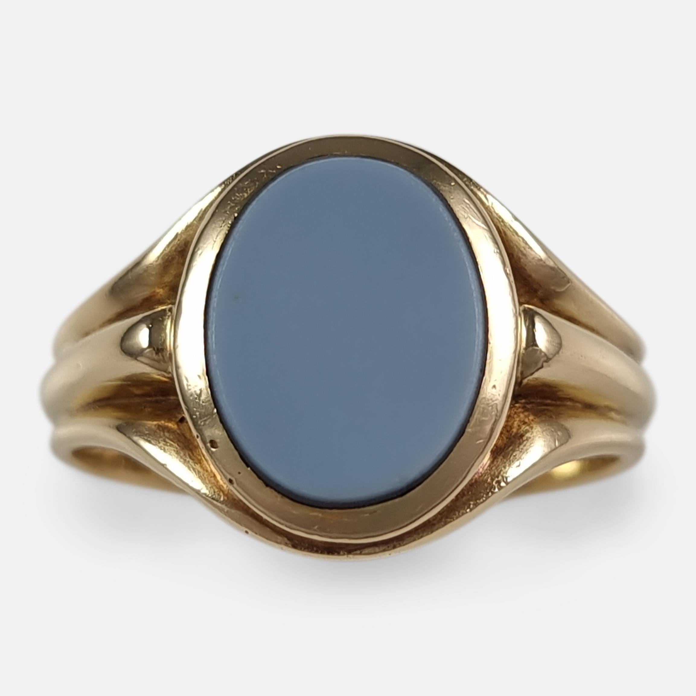 A George V 18ct yellow gold banded onyx signet ring. The signet ring is set with an oval banded onyx, which is grey and black in colour, leading to a reeded shank.

The ring is hallmarked with Birmingham assay office marks, the date letter 'n' to