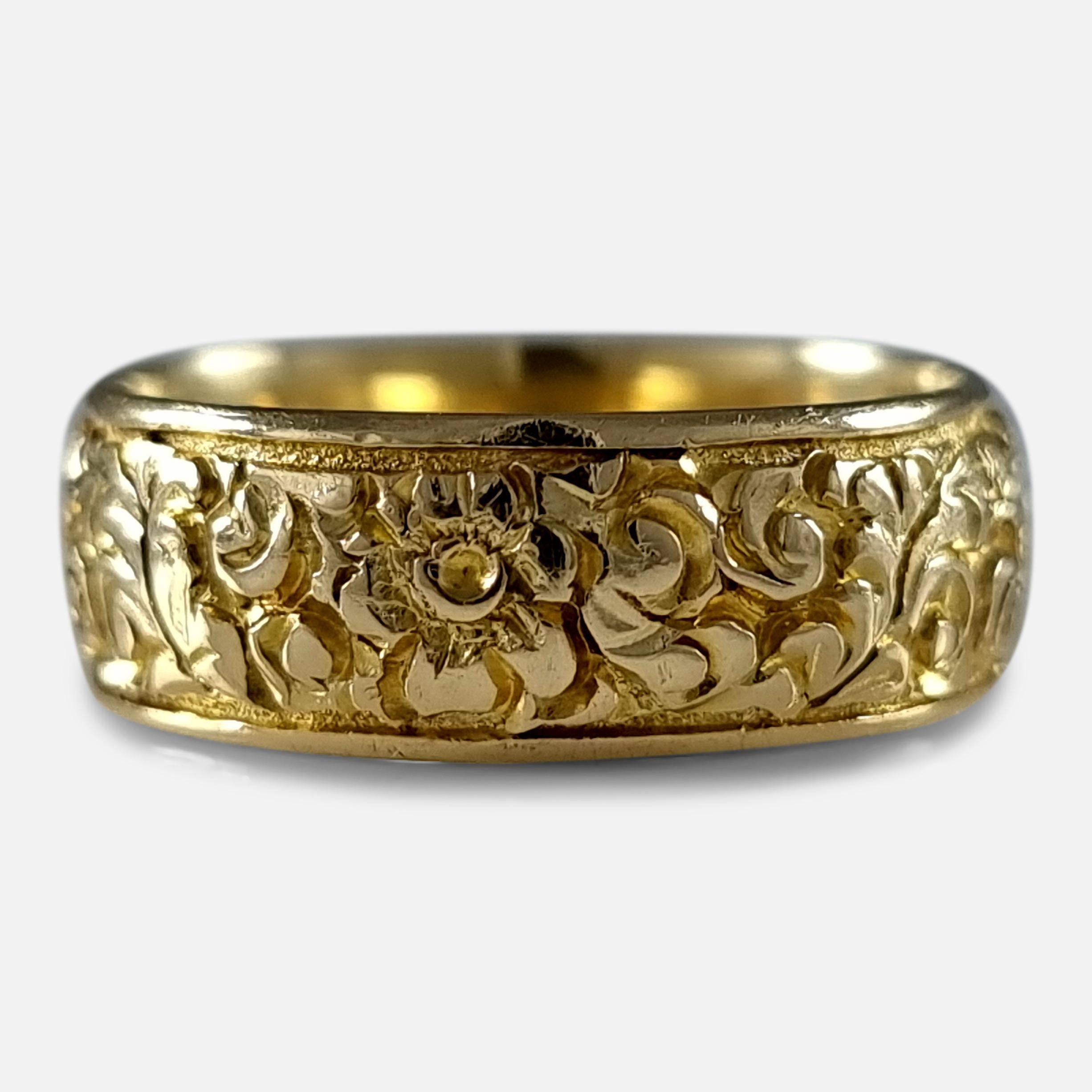 A George V 18ct yellow gold engraved Keeper ring. The ring is engraved with an embossed foliate decoration.

The ring is hallmarked with Chester marks, '18' for 18 carat gold, and date letter 'a' to denote 1926.

Assay: - .750 Gold (18ct).

Period: