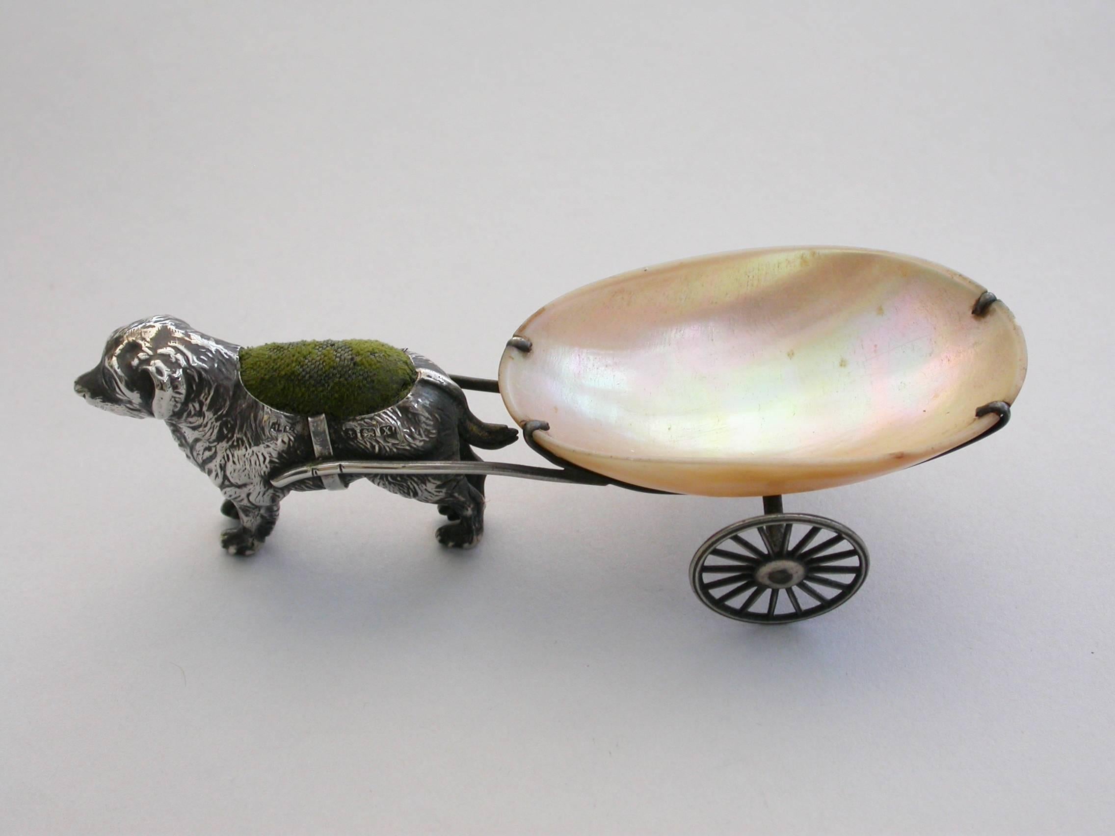 An extremely rare George V novelty silver Pin Cushion, modeled as a dog (possibly a Newfoundland) pulling a shaped mother-of-pearl cart on two wheels. The dog realistically modeled with fine detail and complete with original velvet cushion.

By