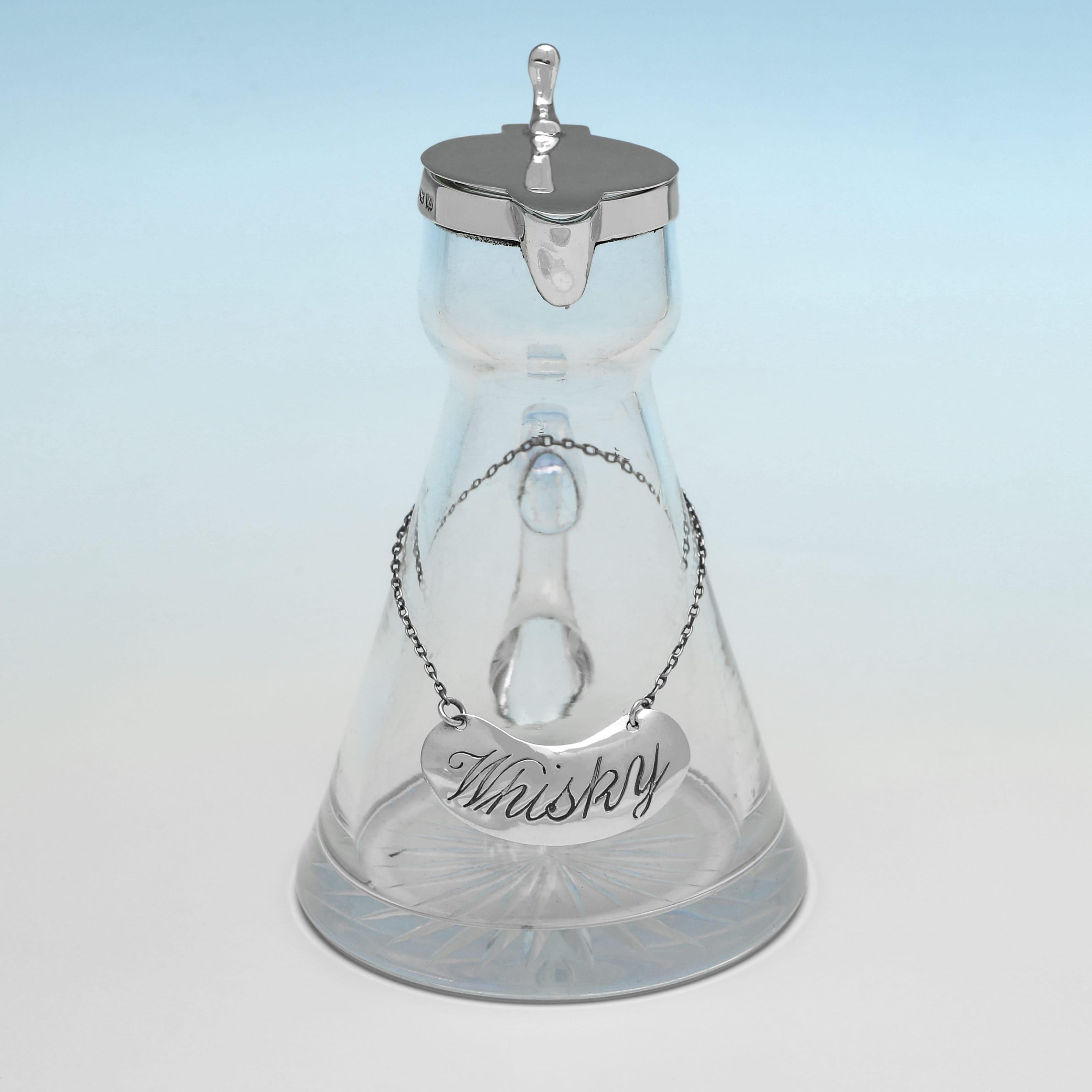 Gepunzt in Birmingham im Jahr 1921 von Alexander Clark & Co. Ltd. ist dieser stilvolle Chota Peg aus Sterlingsilber und Glas aus der Zeit Georg V. schlicht gestaltet, mit einer silbernen Fassung und einem silbernen Deckel sowie einem silbernen