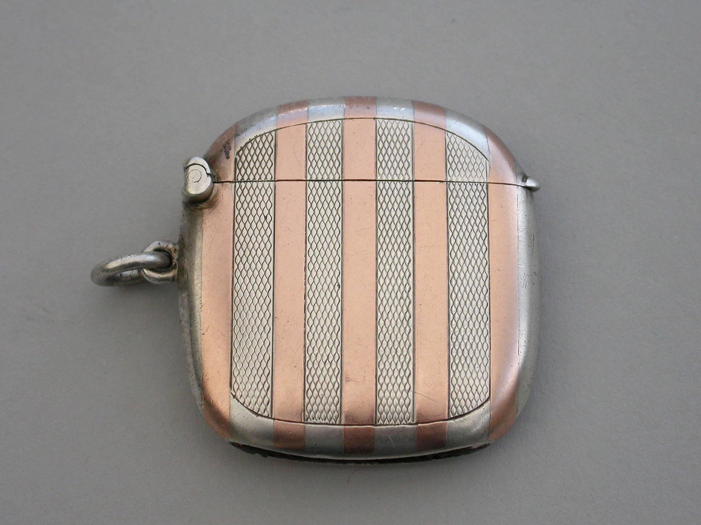 A good early 20th century silver and rose gold vesta case of rounded rectangular form with sprung hinged lid and attached suspension ring, the body decorated with stripes of rose gold and engine turned silver.

By Sampson Mordan & Co, Chester