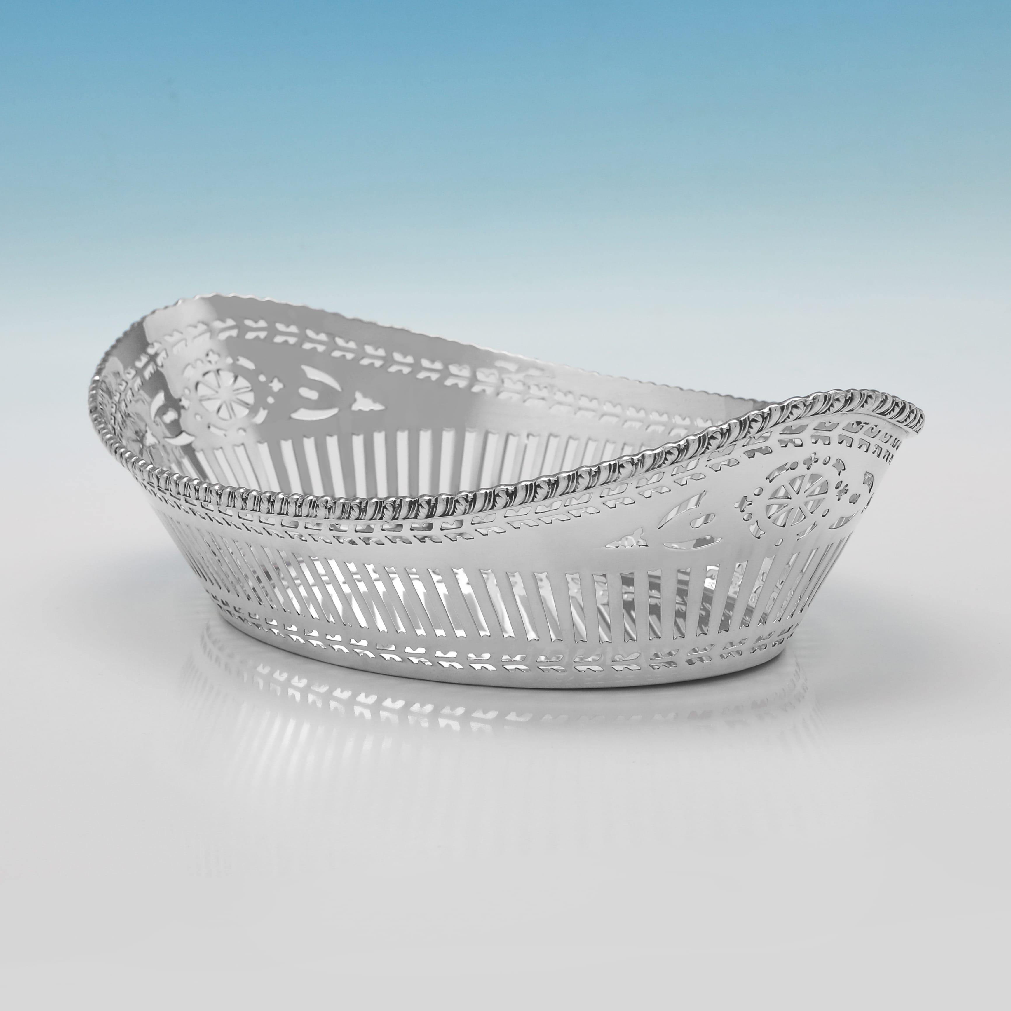 Poinçonné à Chester en 1916 par Barker Brothers Ltd, ce joli plat à pain en argent massif de style George V est de forme ovale et présente un décor ajouré sur le corps et une bordure à godrons. Il mesure 7,5 cm de haut, 29,5 cm de large, 18 cm de