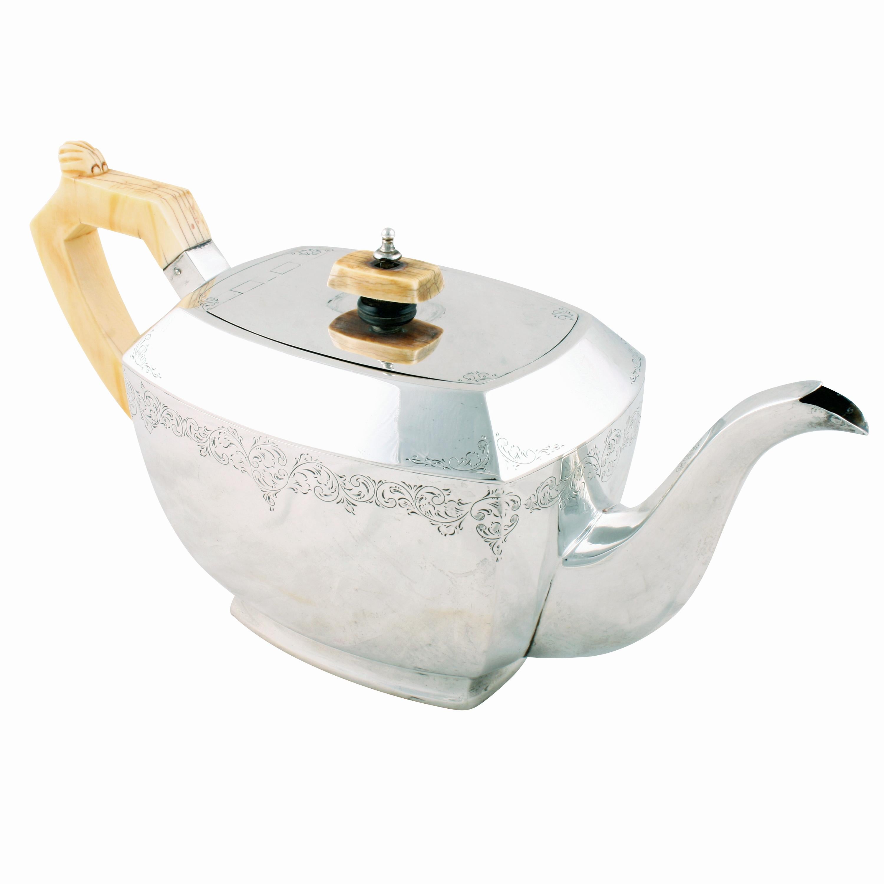 A 20th century George VI sterling silver teapot.

The teapot has sterling silver hall marks for Edinburgh, the year 1938 and a maker's mark for Henry Tatton & Son.

The teapot is in an Art Deco design with a carved ivory handle and a knob for