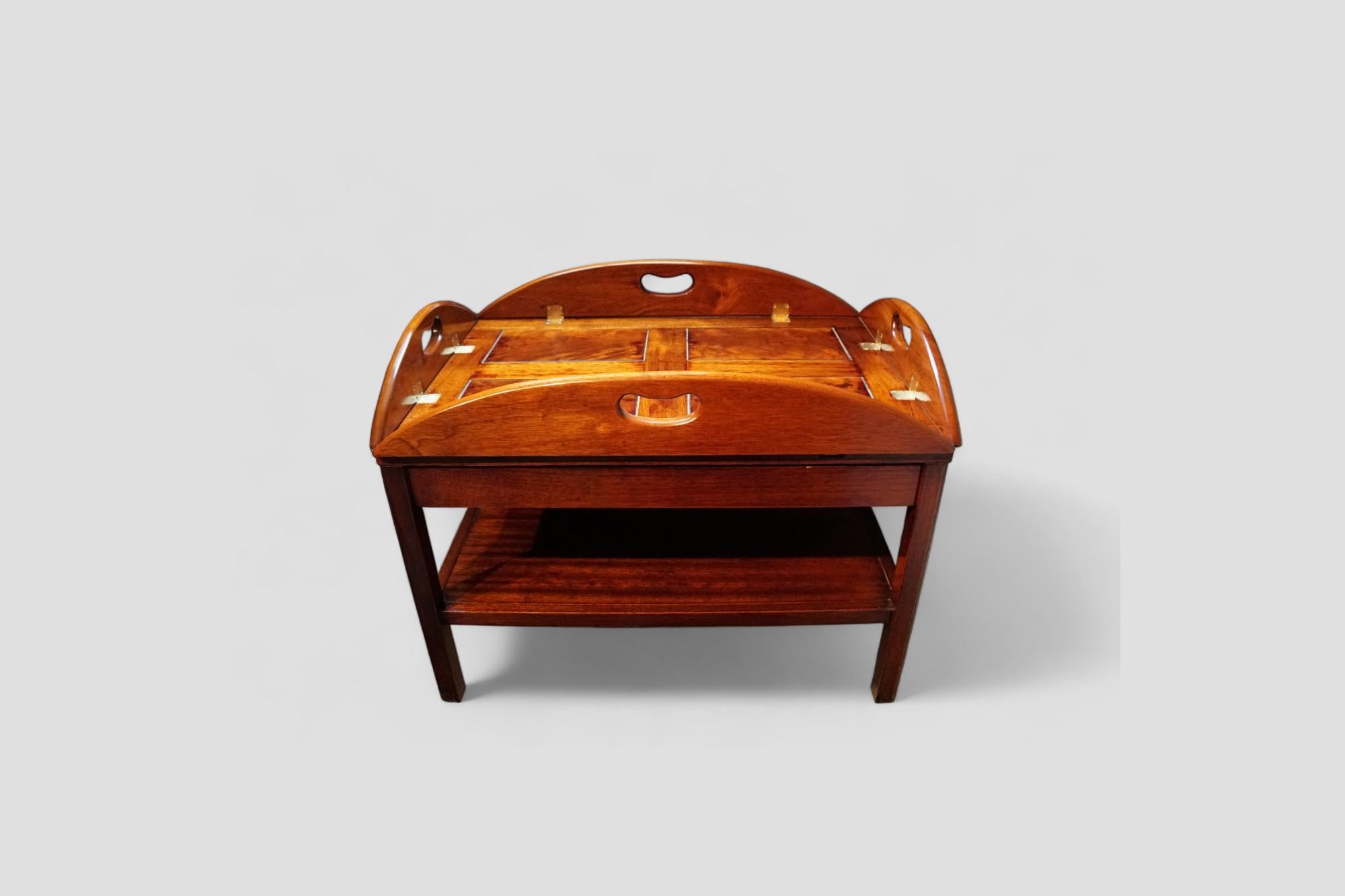 Butlers tray coffee table 
This butler’s tray on stand is made in mahogany. It is a coffee table of high-quality character and lovely on the eye. It is a lovely warm colour.
The classic butlers’ tray with the fold down sides, has the 4 feature