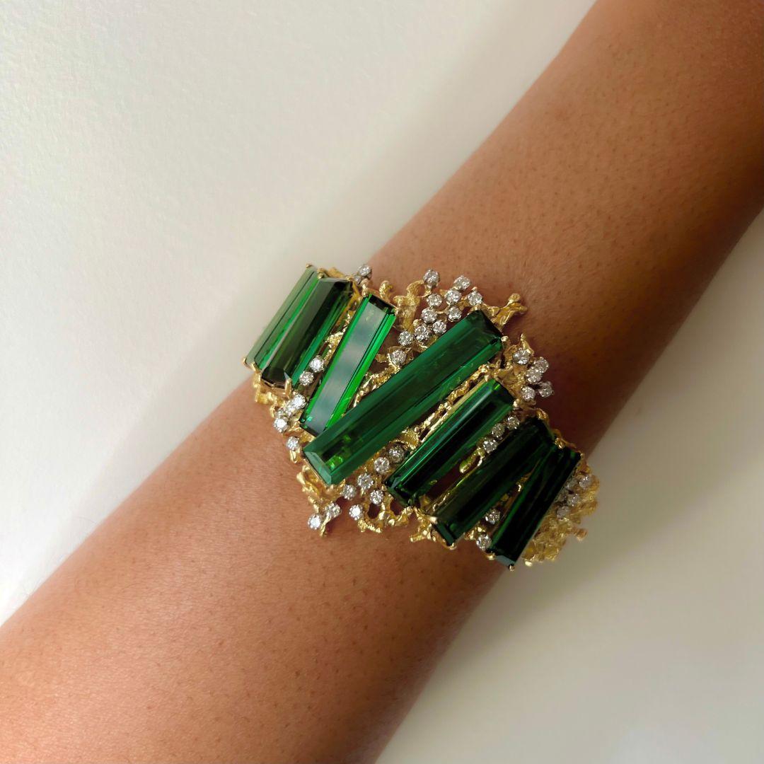 A bold, one-of-a-kind baguette-cut tourmaline, diamond, 18 karat textured gold and platinum bracelet, by George Weil, c. 1970. Weil has been a sculptor, painter, netsuke carver, and jeweler. This piece features seven long slices of baguette-cut