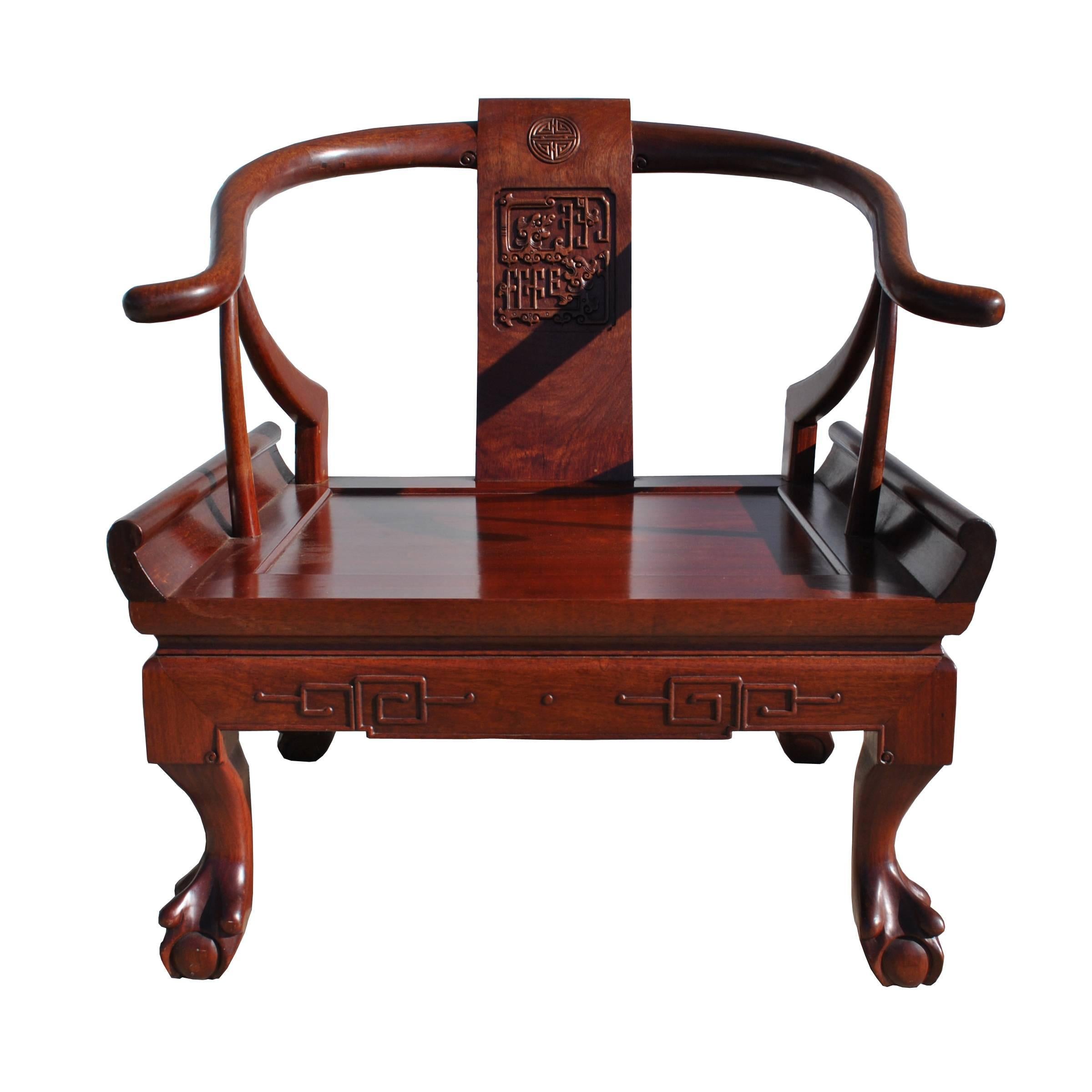 George Zee and Co
Hong Kong.
 

 Chinese Ming style horseshoe chair in rosewood
by George Zee and CO.
 
A contemporary rendition of the traditional Ming chair in rosewood.
Clawfoot and ball with horseshoe arching back.
Embellished with