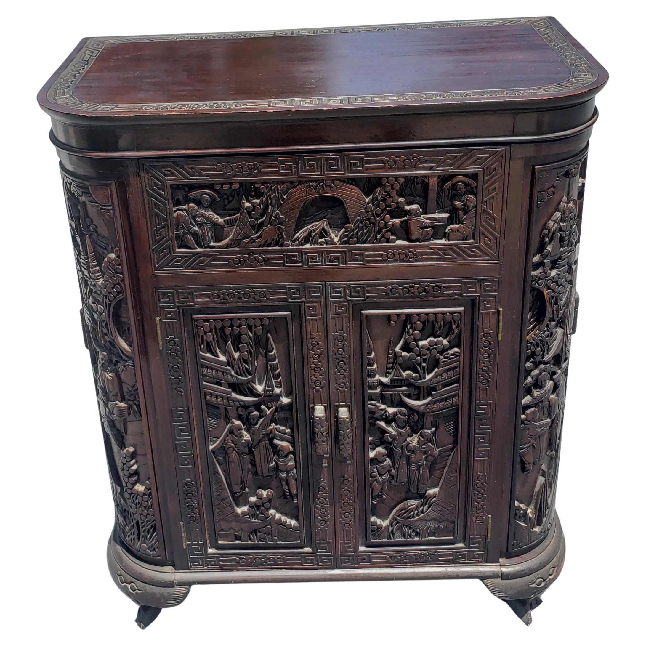 A very sophisticated, heavily hand carved Asian style dry bar , liquor cabinet featuring two central front doors, and 4 side doors, two on each side. Open  Flip top to reveal an amazing carving job on the inside.  Plenty of storage for your liquor,