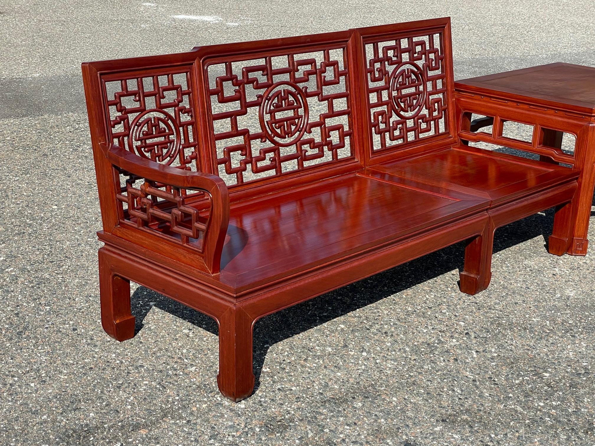 Extra large rosewood sectional by George Zee features hand carved chinoiserie style fretwork and a matching corner table. Can be configured in several different ways. Purchased new in the mid 1960s by the previous owner. Good condition with minor