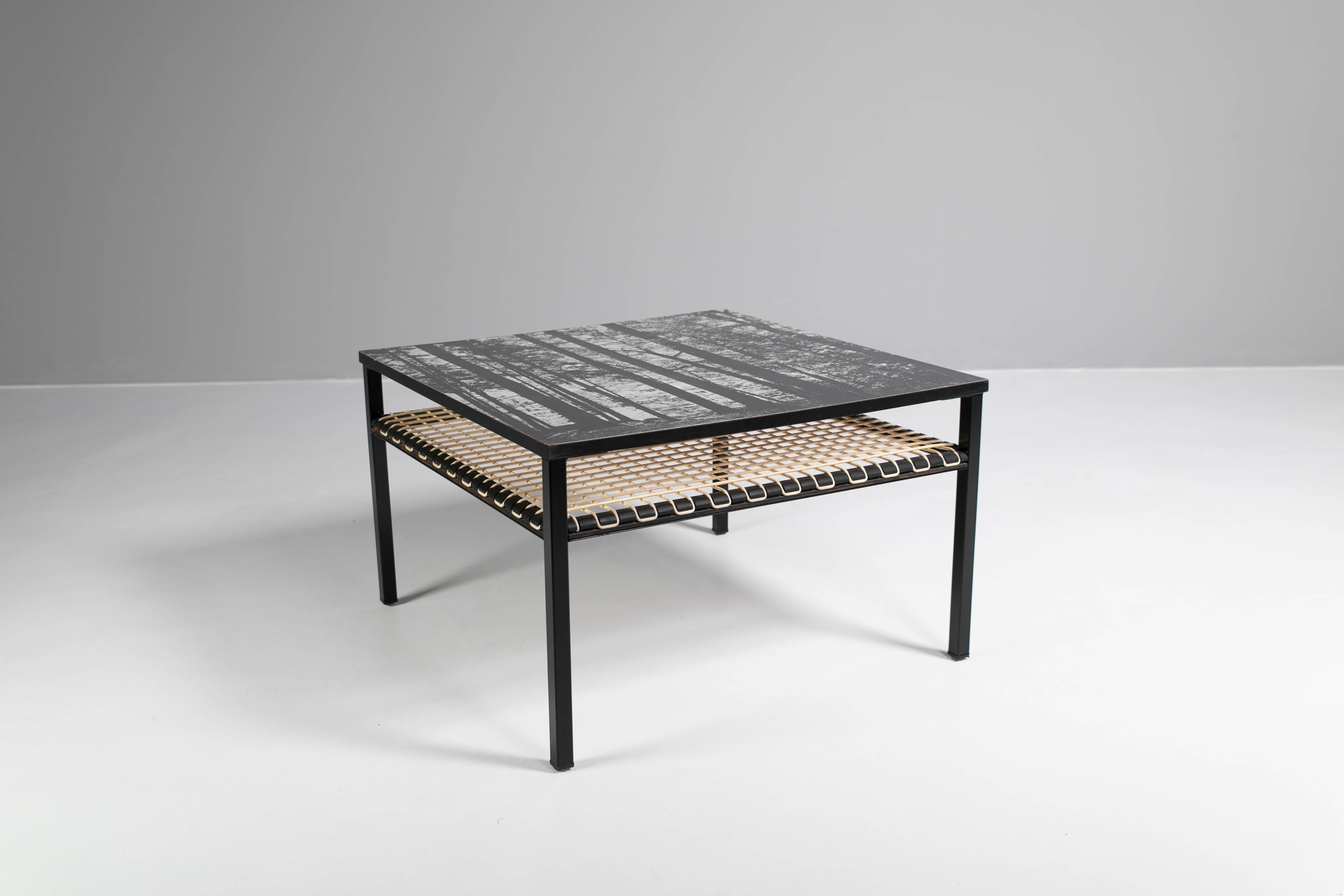Coffee table with print-top formica top on wood. 
Metal base in black lacquer.
Bottom shelf covering with vinyl cord.