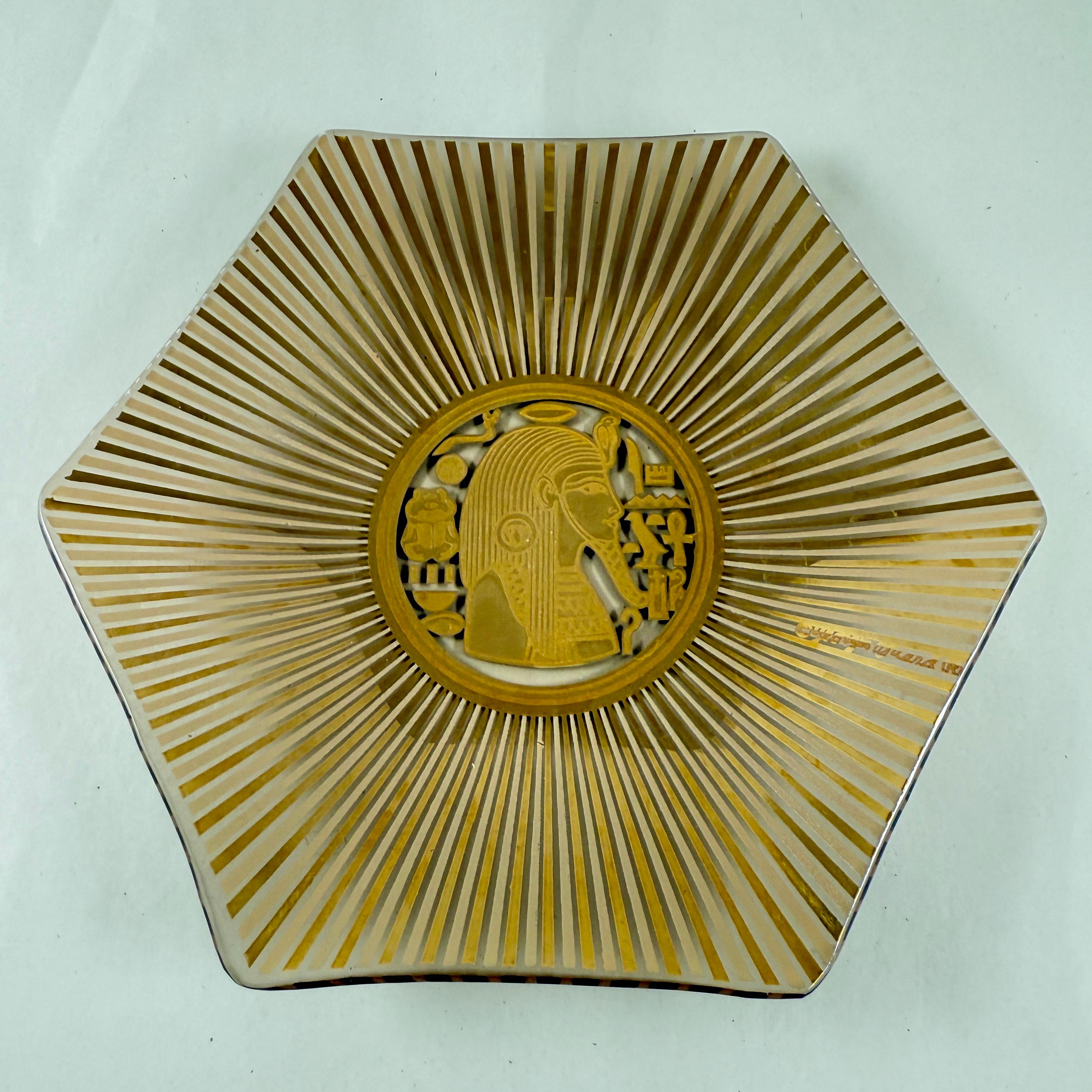 Vida-Poche a sei lati in foglia d'oro dello Studio A di Georges Briard, 1957-1959.

Prodotto in collaborazione con Glass Guild, il piatto è impreziosito da una foglia d'oro a 24 carati.

Il medaglione centrale mostra la testa di un faraone egiziano
