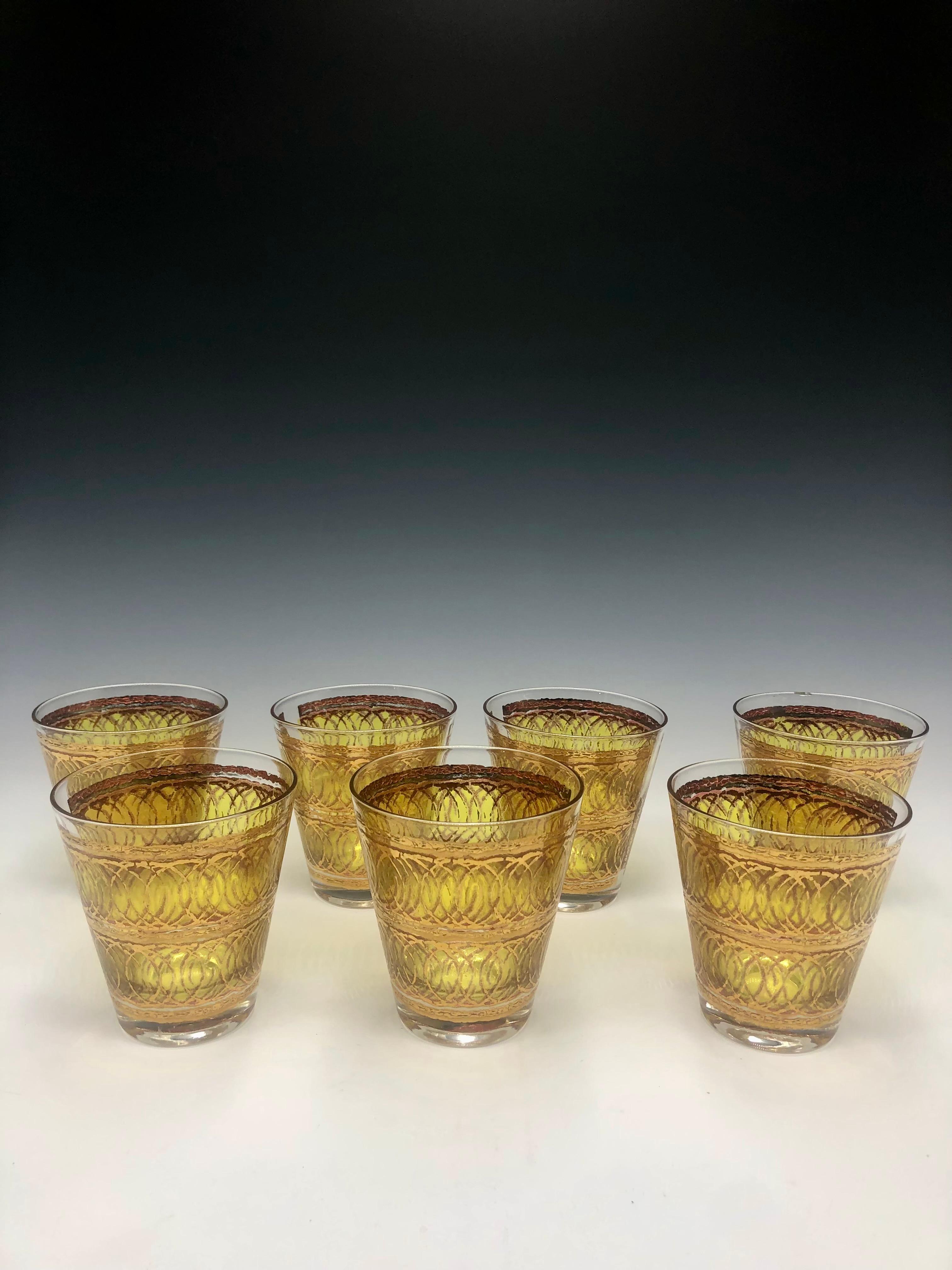 A glamorous set of six mid-century modern tumbler glasses by Georges Briard, celebrated for his bold and opulent glassware designs. Each glass features a luminous yellow base with intricate 22k gold lattice decoration, signed Georges Briard along