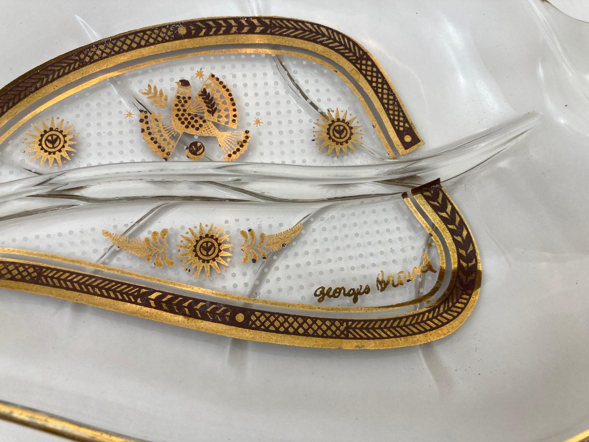 Plat à noix vintage en verre en forme de feuille avec bord et design dorés, 1960's signé Georges Briard.
Il s'agit d'un objet moderne du milieu du siècle qui ferait un excellent cadeau pour quelqu'un que vous connaissez et qui aime cette époque.
En