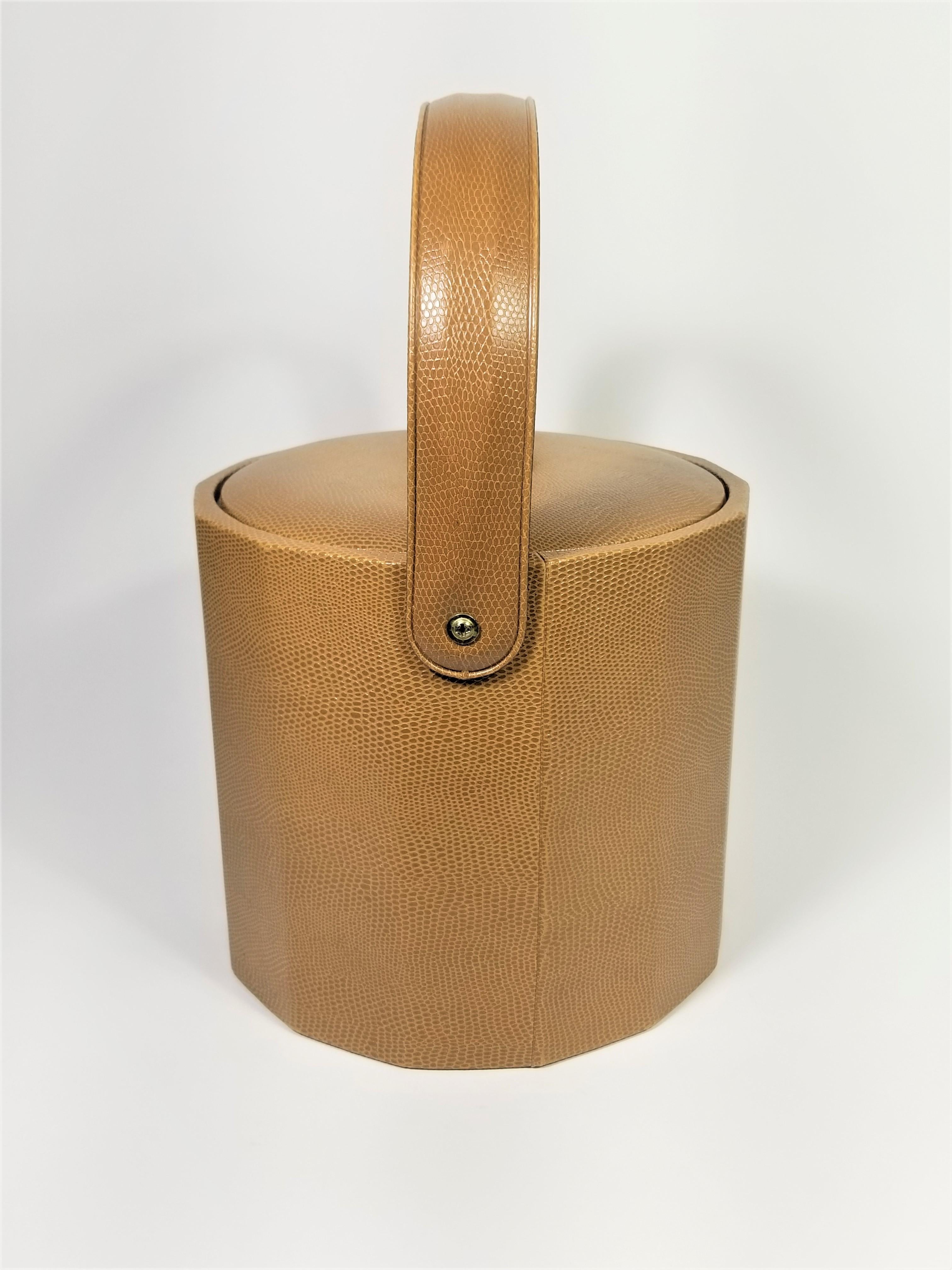 1960s Mid Century Georges Briard Ice Bucket. Carmel color textured faux leather with unpolished brass handle on lid. Signed on bottom. Very good condition. 

Height with handle up: 12.0 inches
Diameter with handle up: 9.0 inches

Height with handle