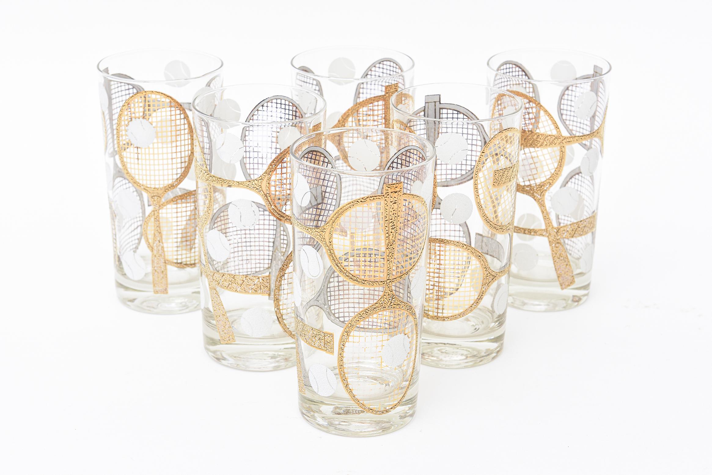 These fabulous signed set of 6 Georges Briard highballs or tall drinking glasses have the subject matter of gold applied dimensional tennis rackets and white painted tennis balls in random form. They have applied gold and silver paint. They are