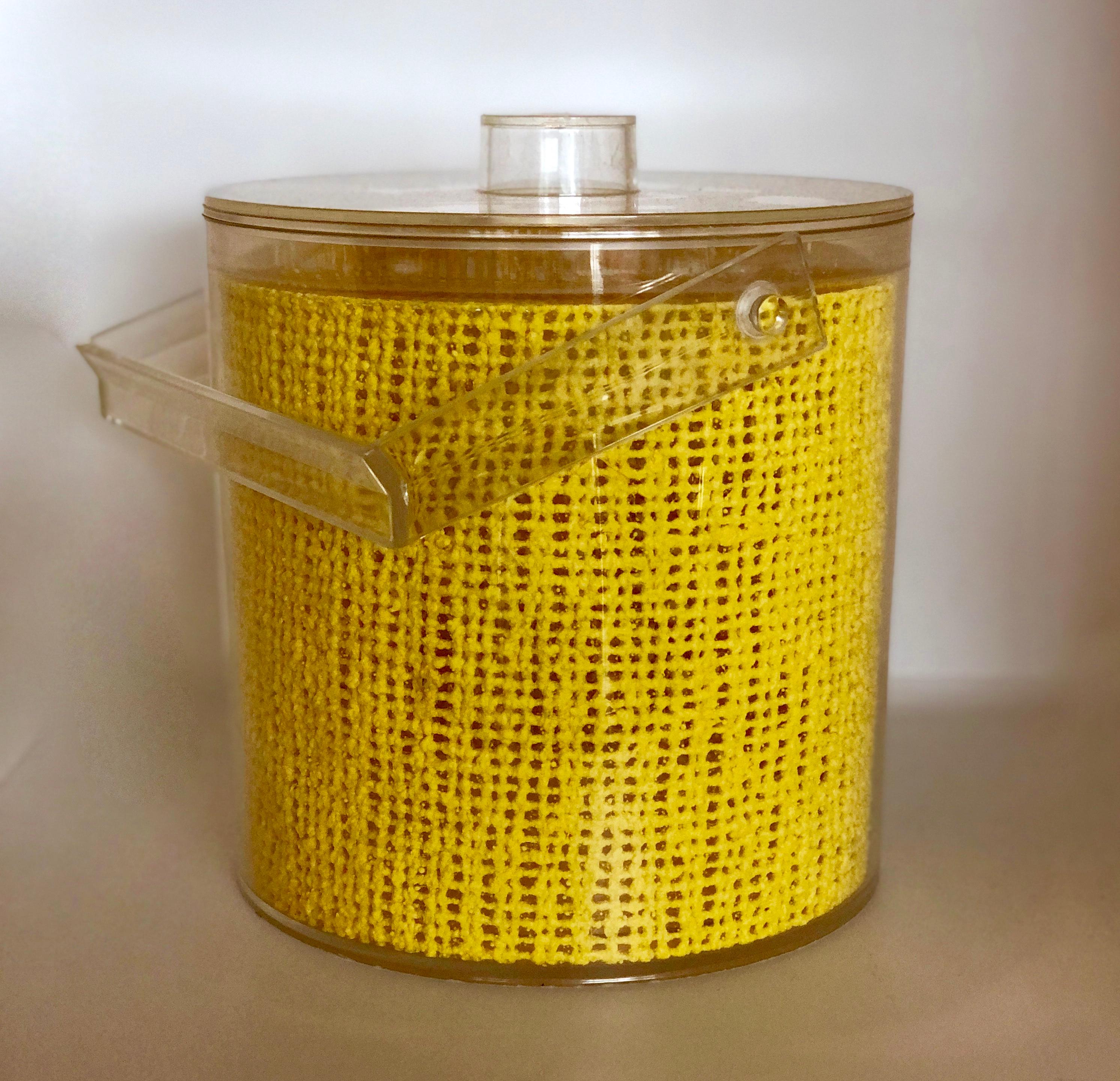 Offered is a Mid-Century Modern Georges Briard embedded yellow raffia Lucite covered ice bucket. A bright pick-me up to any day, this cylindrical Georges Briard Lucite ice bucket stands apart from the others thanks to the vibrant yellow matting