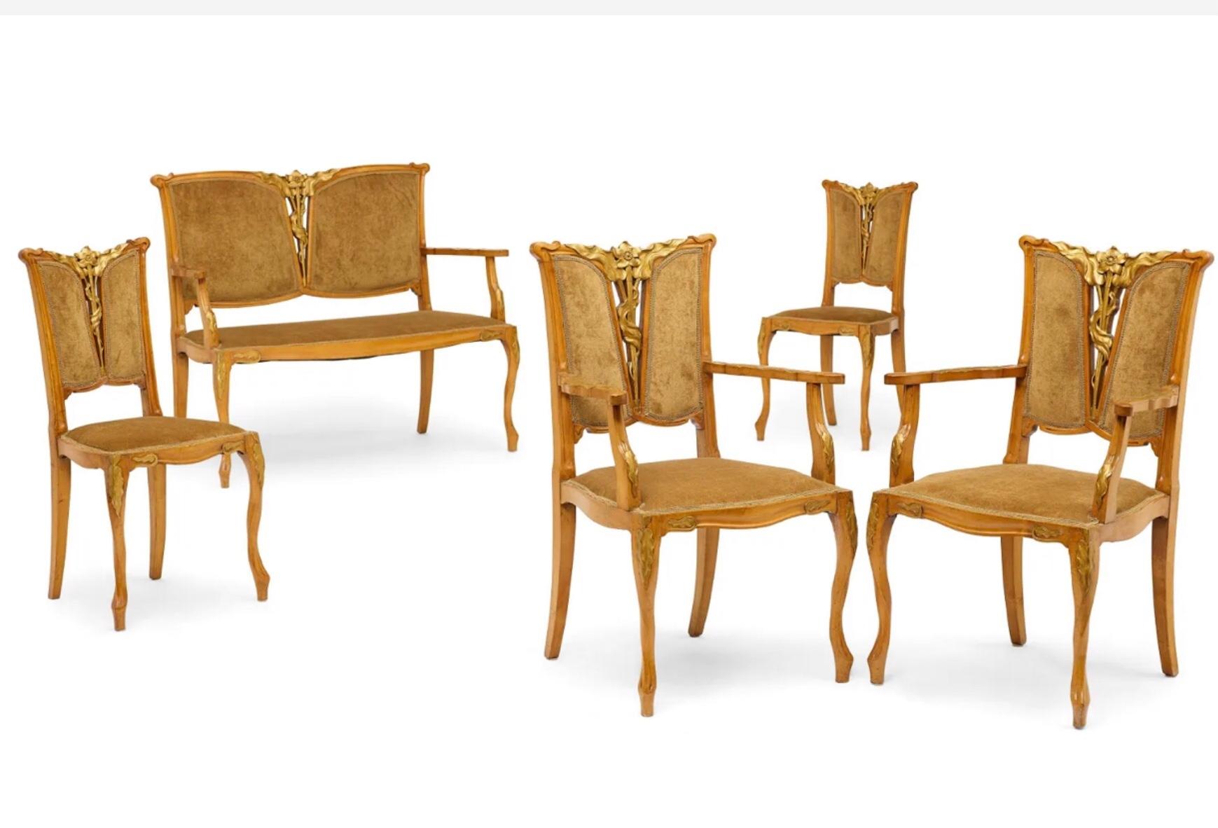 GEORGES DE FEURE (1868-1943), 
Five Piece Salon Suite
circa 1900

Walnut and parcel-gilt, comprising a settee, two armchairs and two side chairs. It is rare to find a full set of period salon Art Nouveau furniture and the style of Georges De