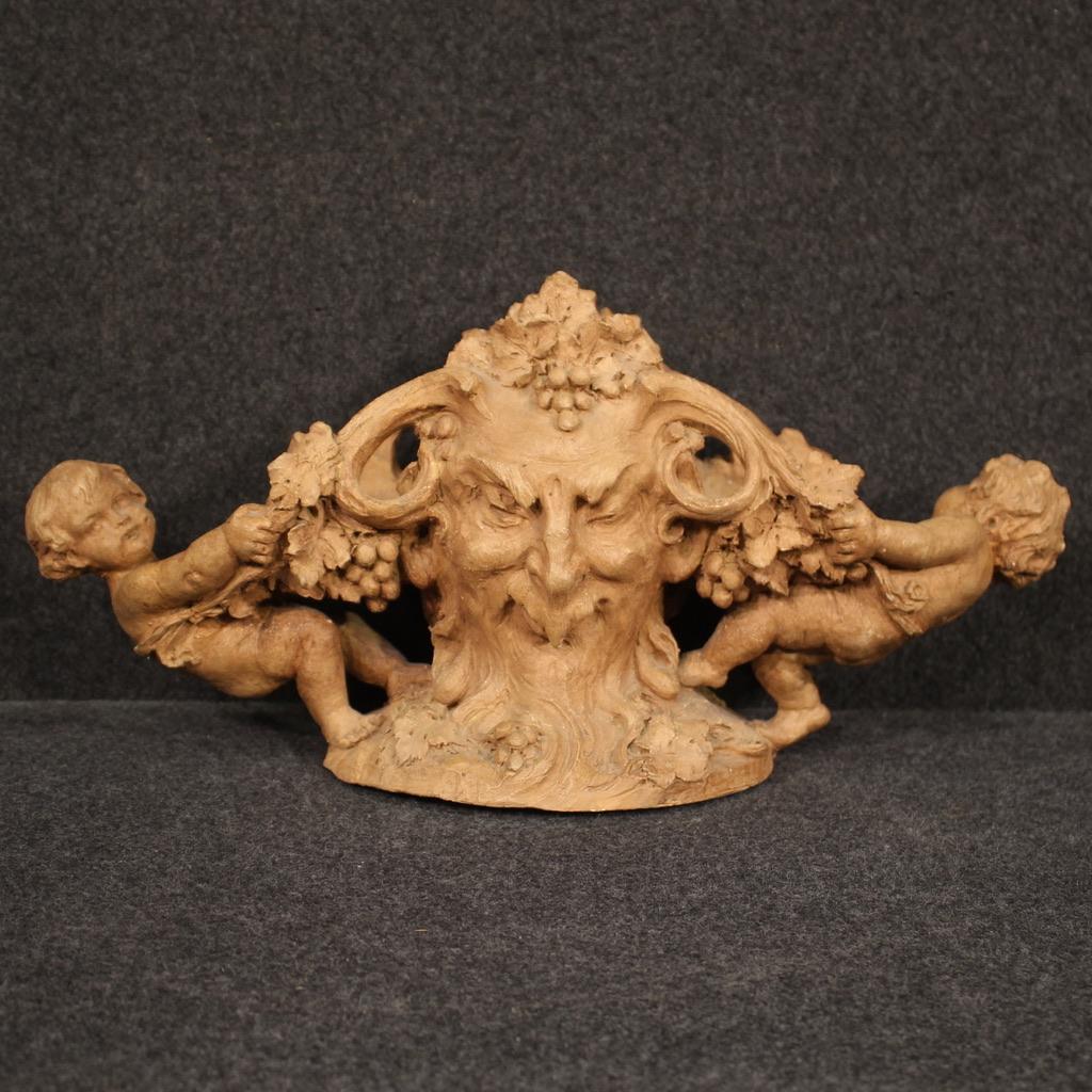 Centre de table français de la première moitié du 20e siècle. Objet en terre cuite finement ciselée avec des masques (visages avec différentes expressions, voir photo) et des figures d'angelots latéraux d'excellente qualité. Sculpture signée sur la