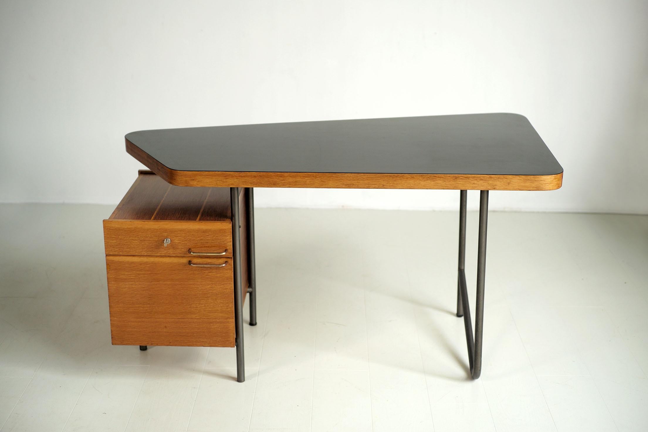 Georges Frydman, free-form desk published by E.F.A., France 1956. Placed on a gray lacquered tubular base, the trapezoidal top is veneered with matt black formica, enhanced by a wide light oak strip. The two-drawer unit is offset to the left,