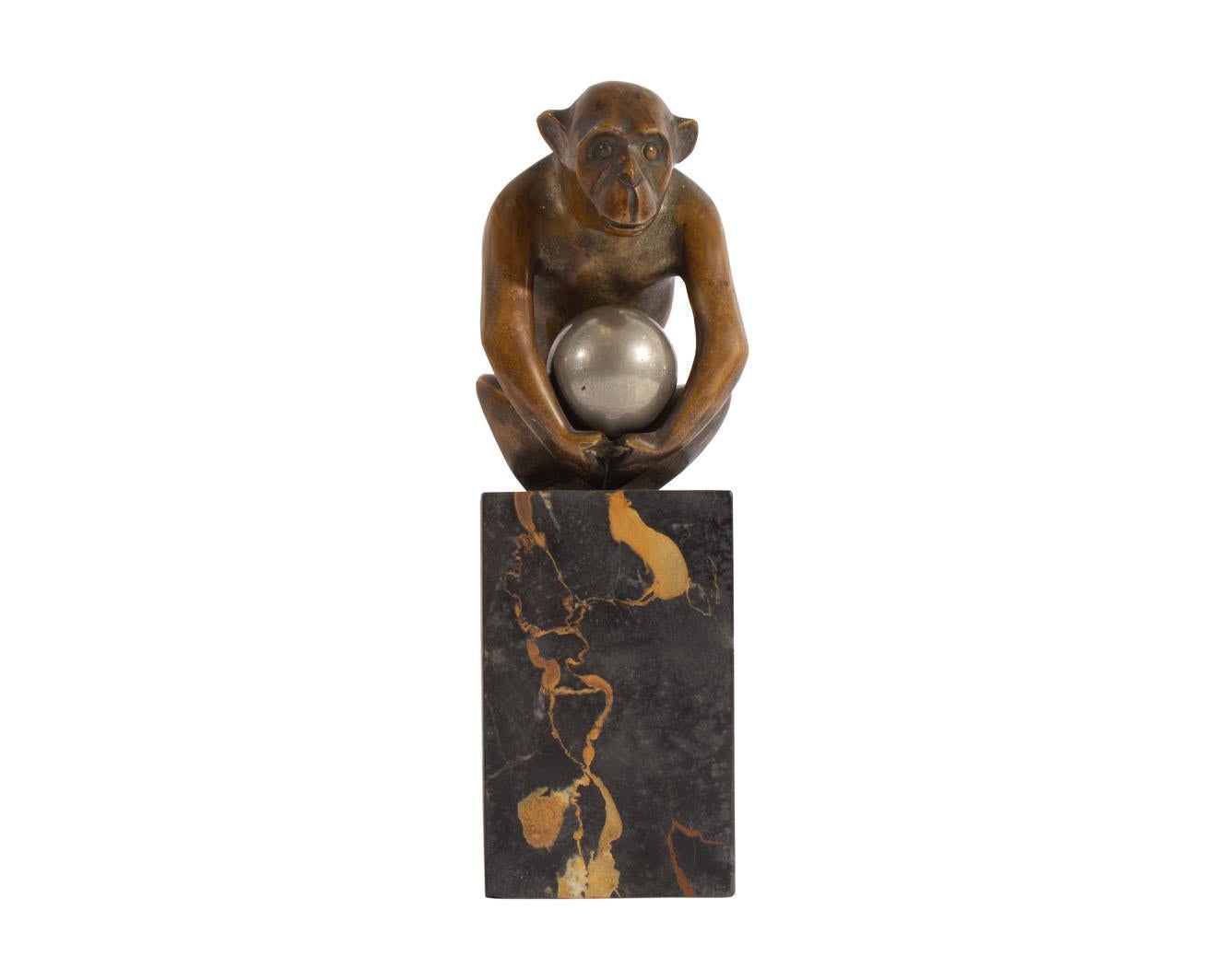 A bronze sculpture of a monkey by the French artist Georges H. Laurent (1880-1940). Signed near the bottom edge of the sculpture, the monkey is depicts seated with arms holding a silvered bronze ball. The sculpture is attached to a stone base.

