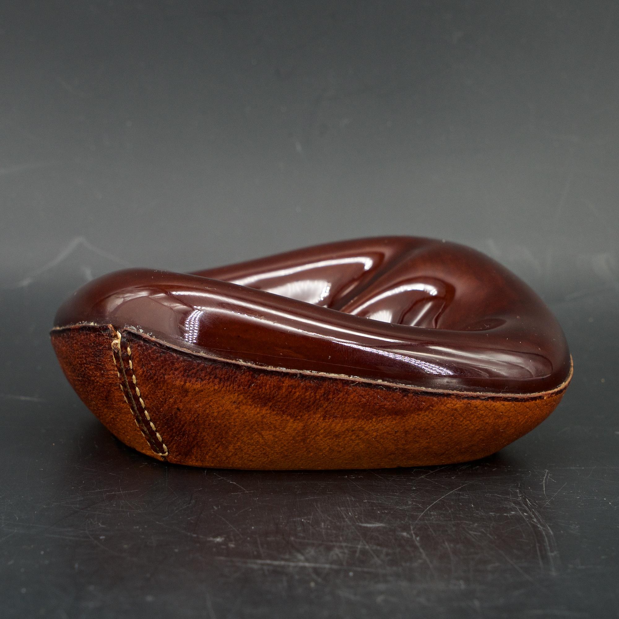 Brown high gloss freeform slipcast dish in leather wrapped bottom. Mfg. Longchamp, France. Design attributed to Georges Jouve.