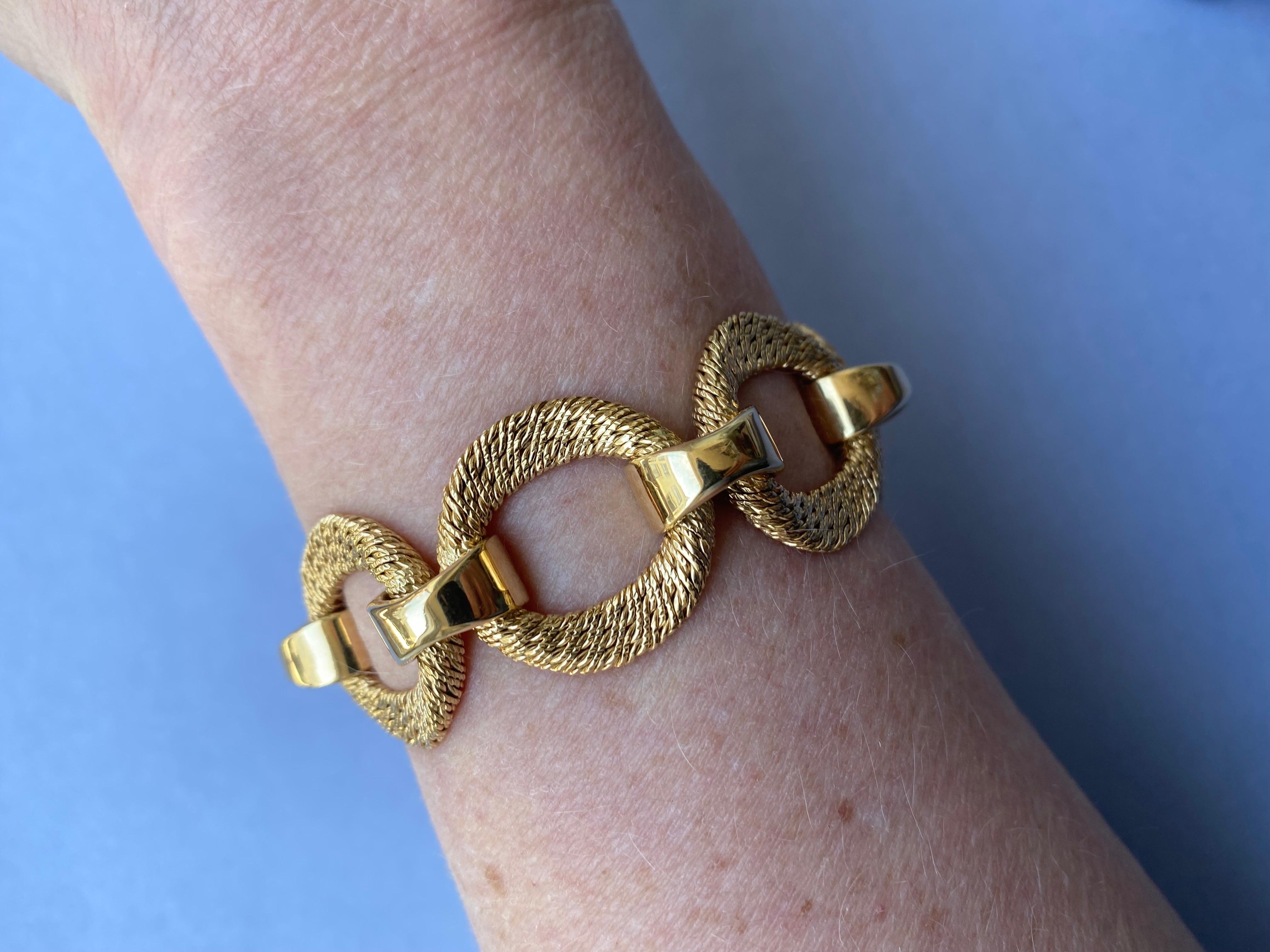 An 18 carat gold bracelet with circular woven links connected by polished domed links, master mark Georges Lenfant, Paris. 

weight: 66.16 grams 
length: 19.5 cm
