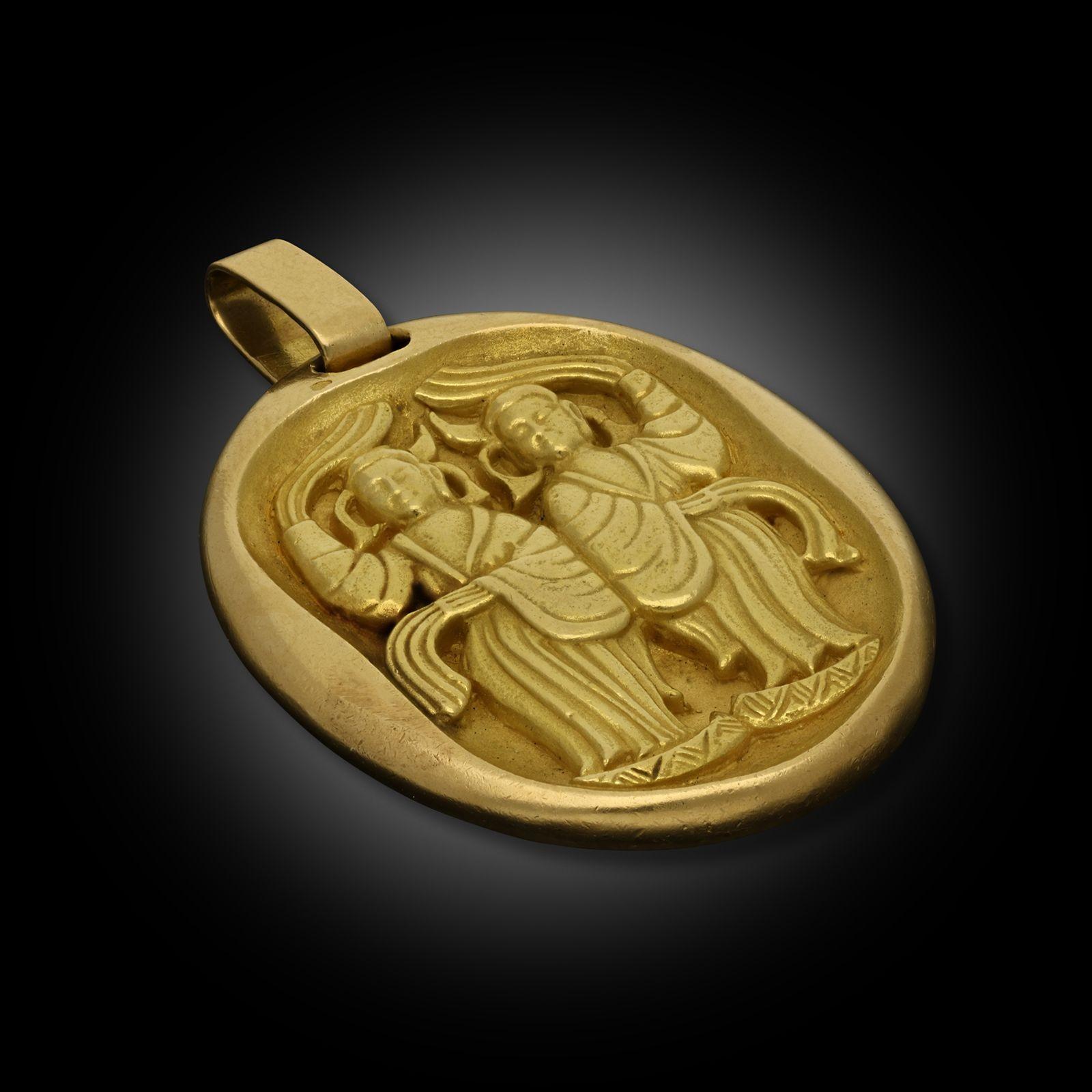 A vintage yellow gold jumbo zodiac Gemini pendant by Georges Lenfant for Cartier, circa 1960. The 18ct yellow gold pendant is engraved to the front with two figures representing the Gemini twins. The reverse has the zodiac symbol for Gemini,