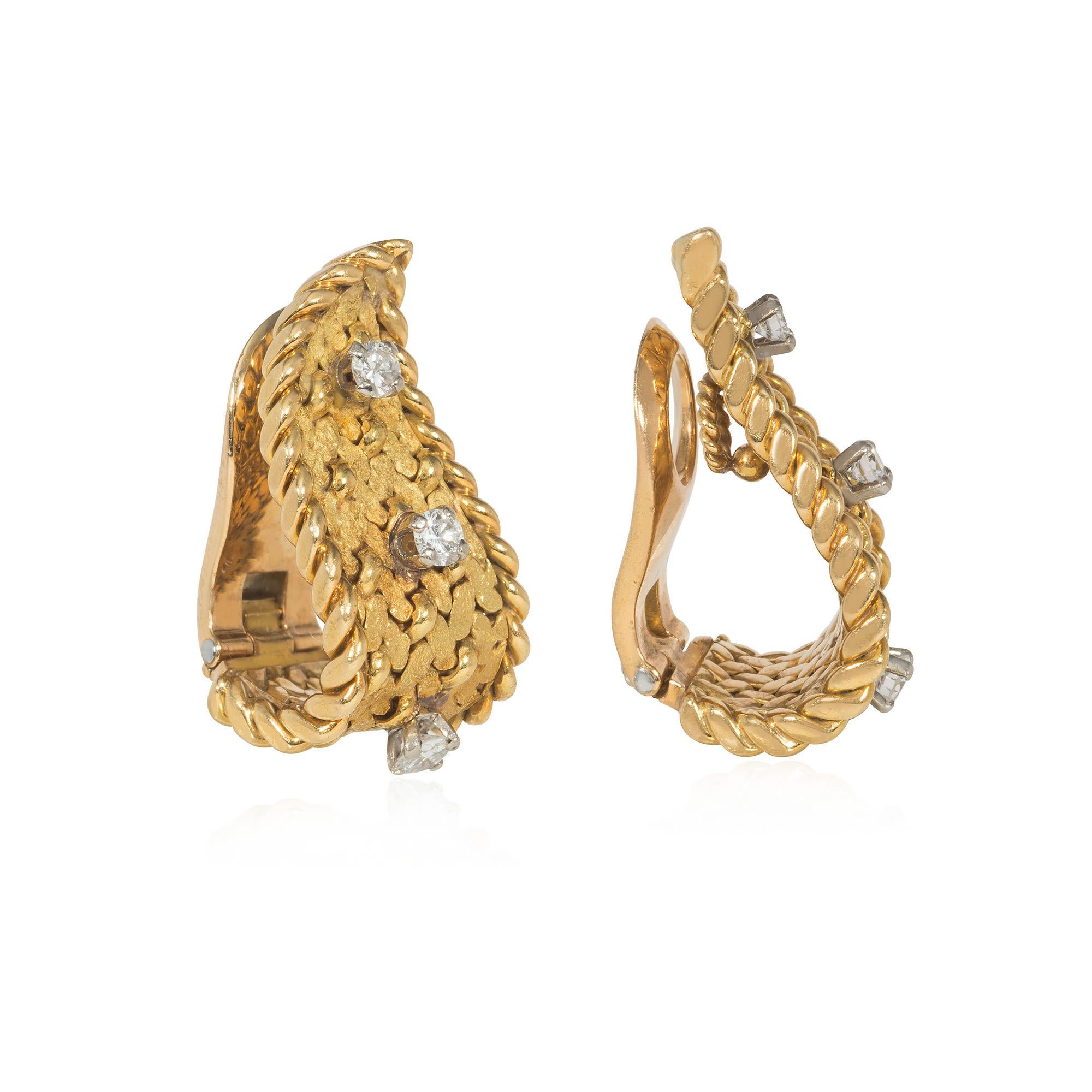 Paire de boucles d'oreilles clips en or et diamants du milieu du siècle, au design de flamme stylisé, les corps texturés et perlés sertis de diamants ronds de taille brillant et avec des bordures en corde torsadée, en 18k.  Georges Lenfant pour