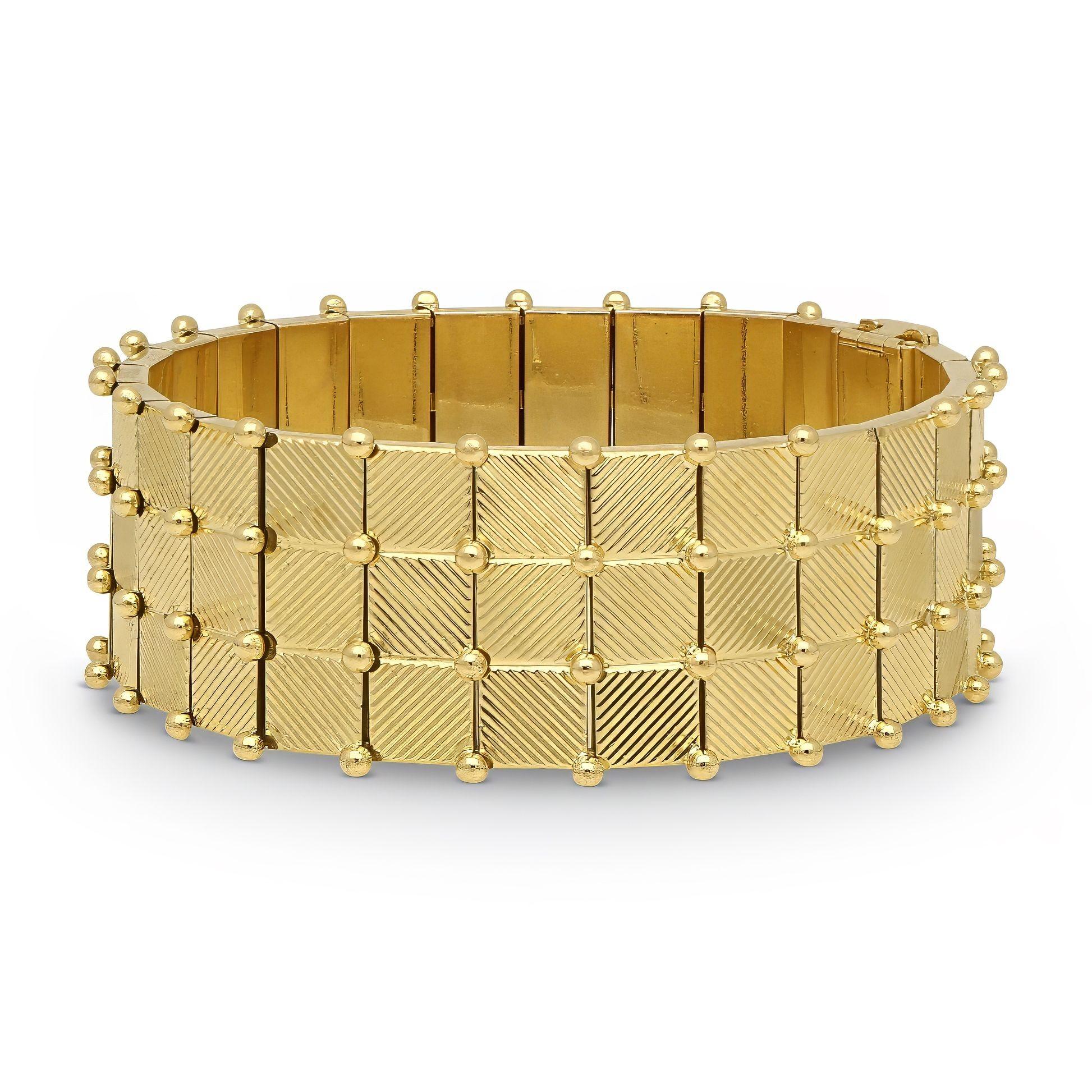 A vintage 18ct yellow gold bracelet made by Georges Lenfant, circa 1960. The bracelet is crafted as articulated gold panels, each to the front engraved with square sections and each engraved with alternate diagonal engraving and separated with