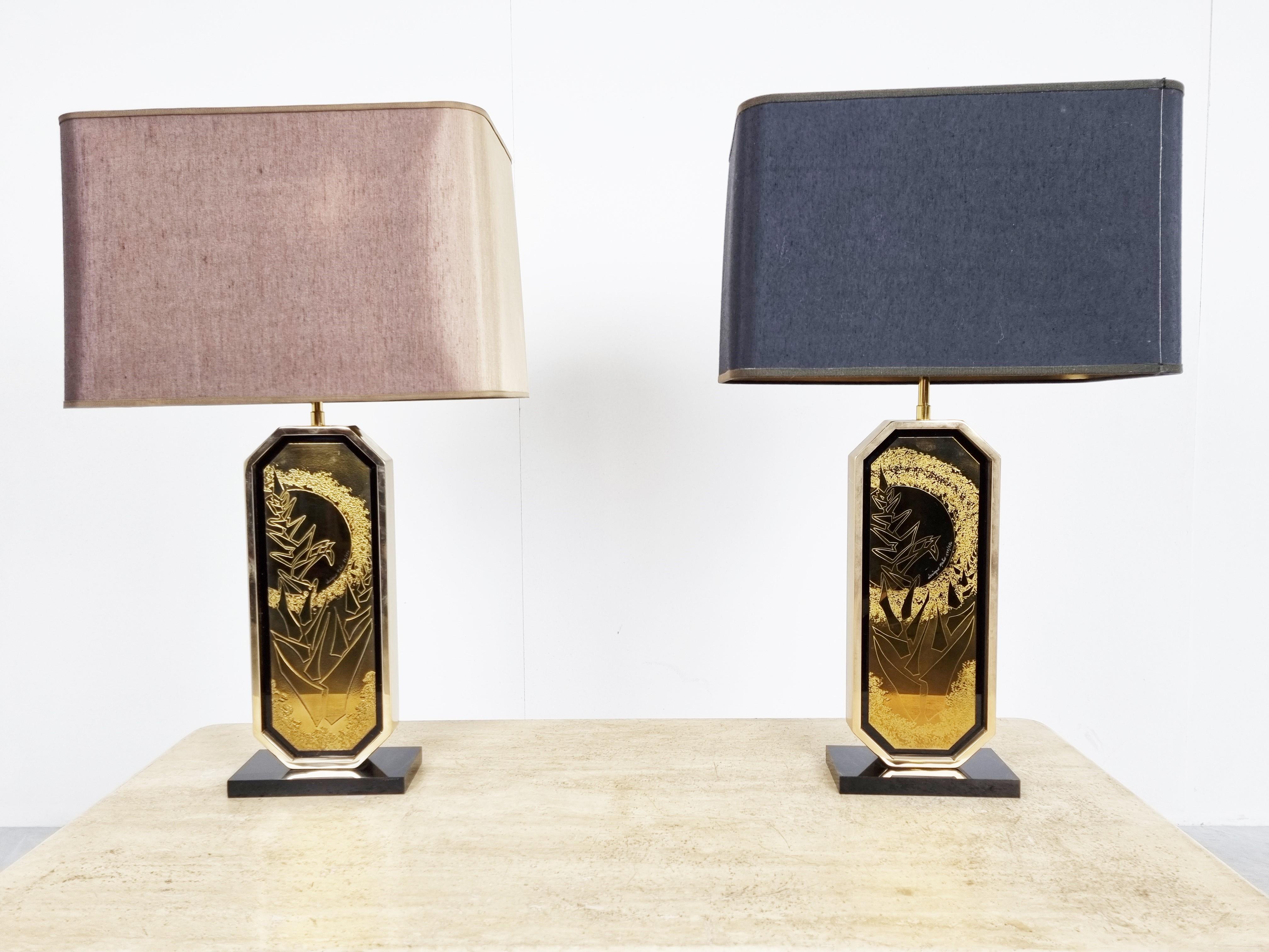 Pair of Hollywood Regency table lamps designed by Georges Mathias in the 1970s and produced by Belgochrom.

The lamps consist of a black lacquered base, a 23kt brass frame holding the etched artwork and finished with the original lamp shades.