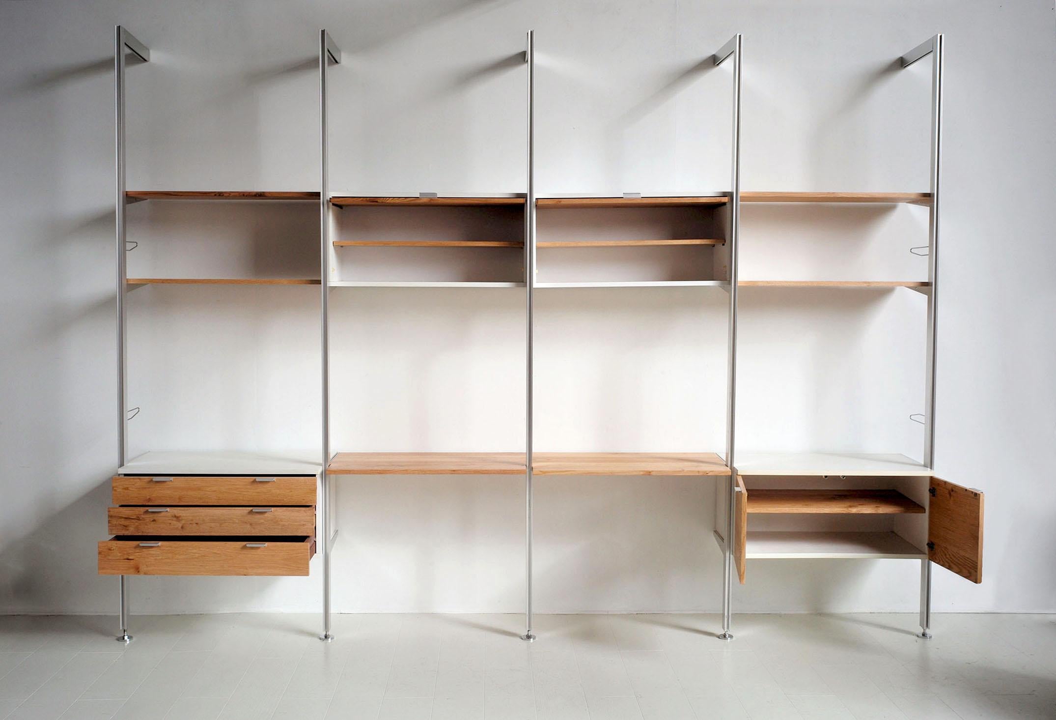 Unique version of the CCS bookcase by Georges Nelson in white melamine and American oak, published by Mobilier international, 1970. The fronts and shelves have been redone in solid red oak. Equipped with 5 floor-to-wall columns, this large bookcase