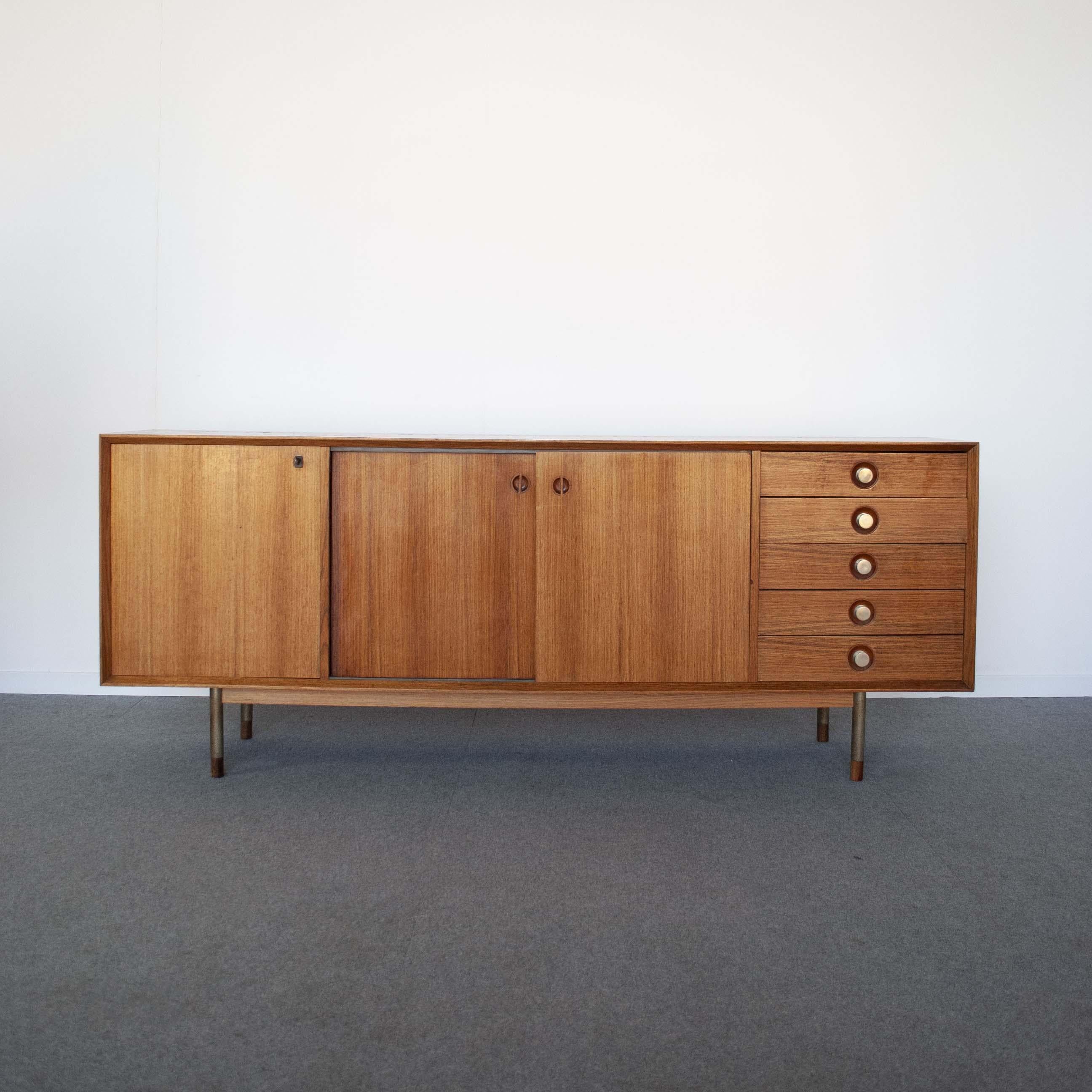 Walnut sideboard composed of four compartments, one with 5 drawers, the other three containing with two sliding doors, designer Georges Nelson, 1960s production.