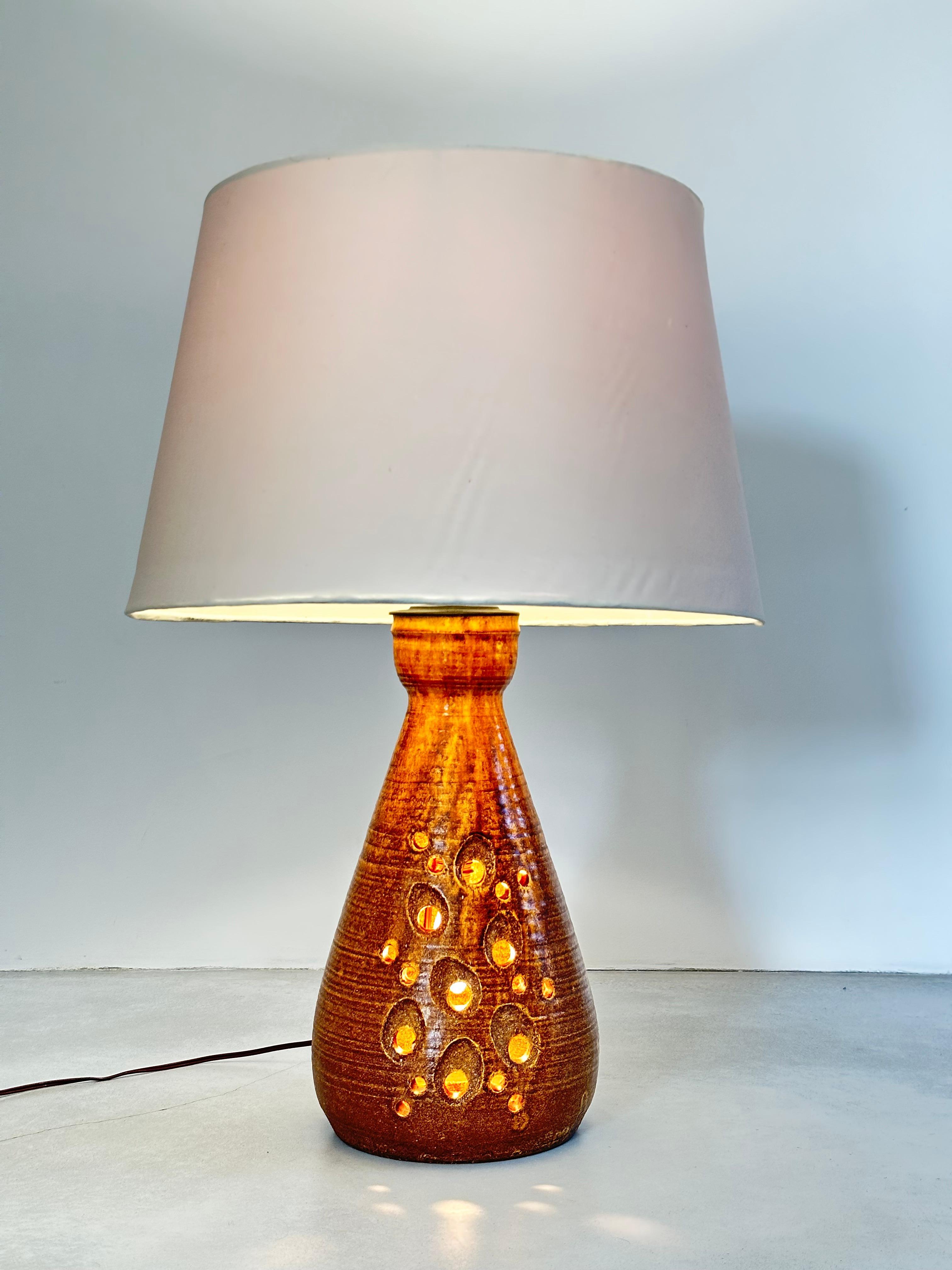 Large fawn-colored enameled sandstone lamp.

The body of the lamp is perforated in several places through which the double lighting diffuses a poetic light.

the lamp is signed 