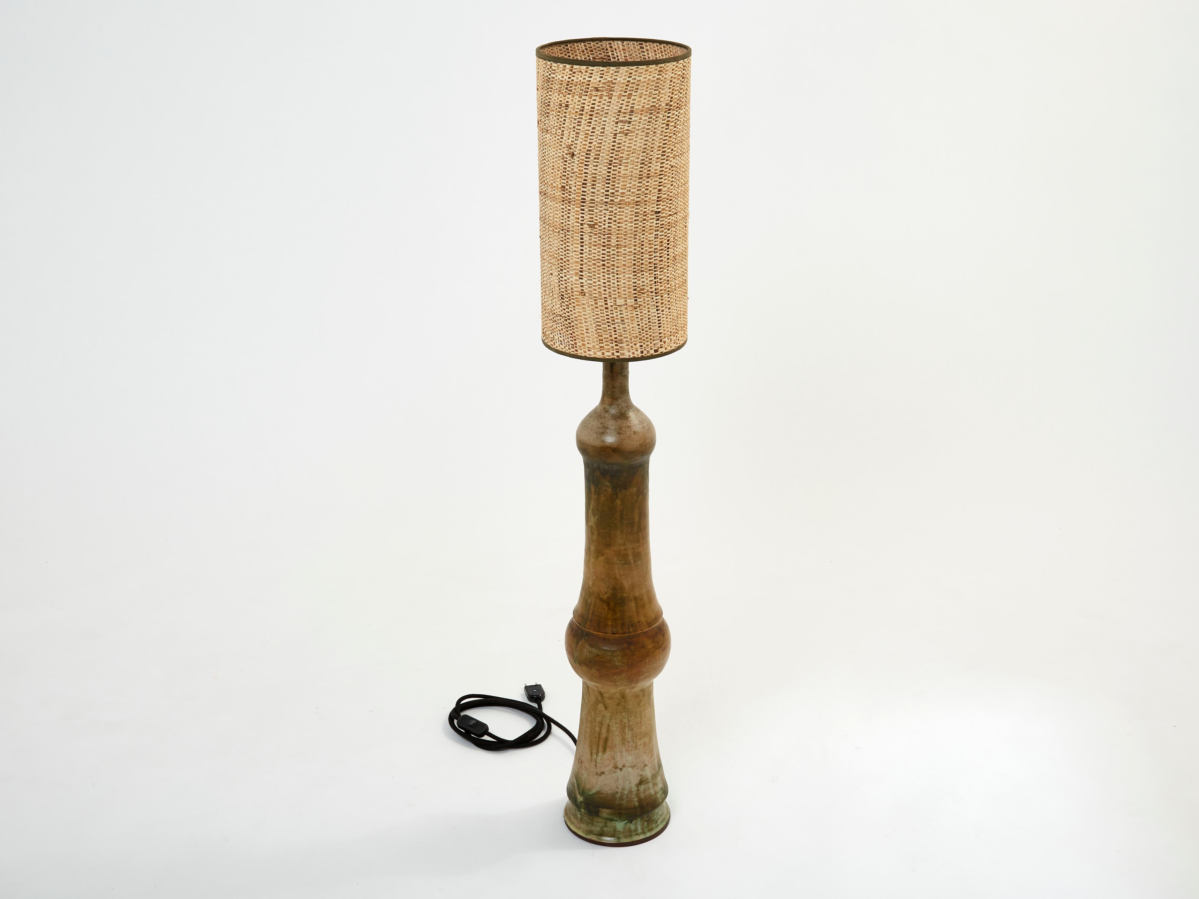 This is a beautiful and tall ceramic lamp signed by Georges Pelletier. This is an early work of his, with beautiful contrast and presence. Matched here with a beautiful rattan shade with brown strapping, for a nice vintage look, this floor lamp will